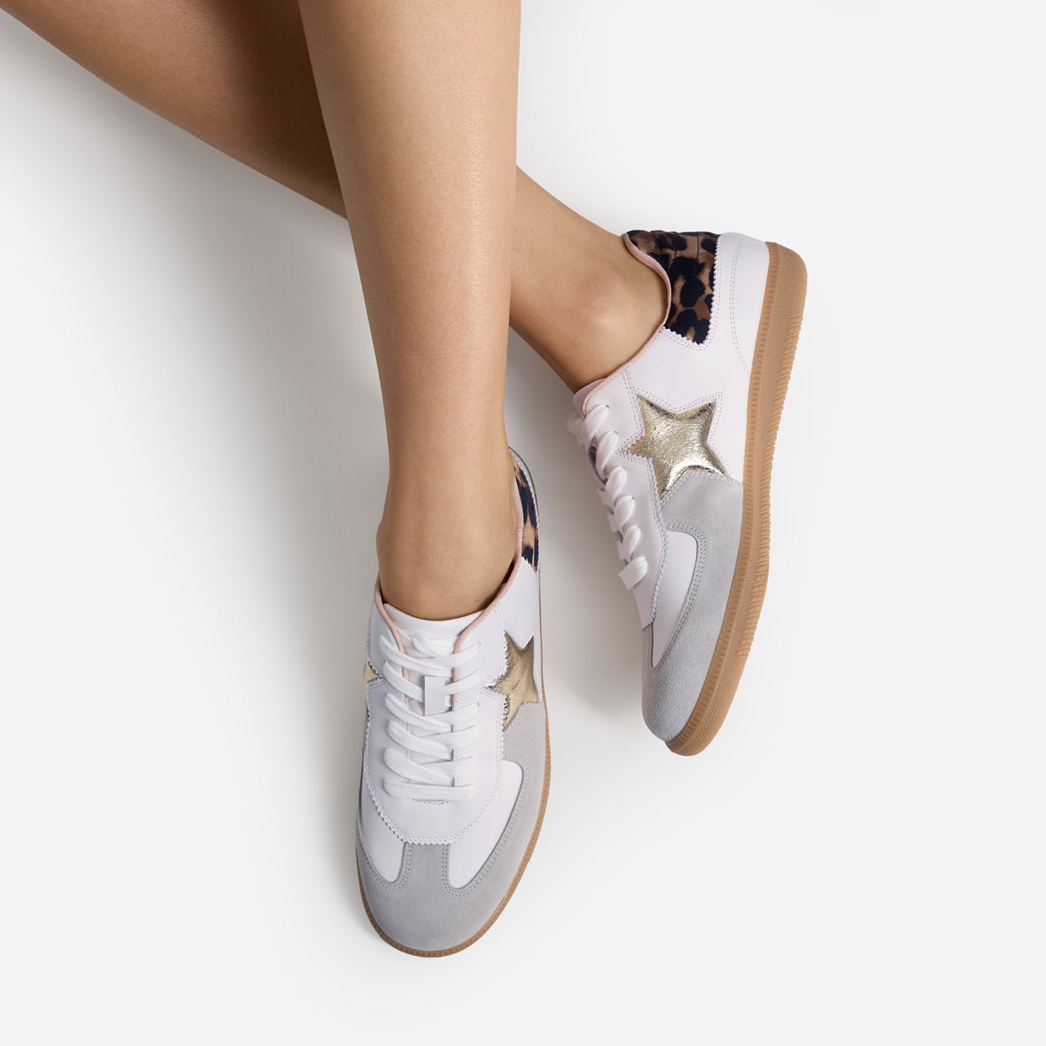 White sneakers with star designs on a light background worn by model