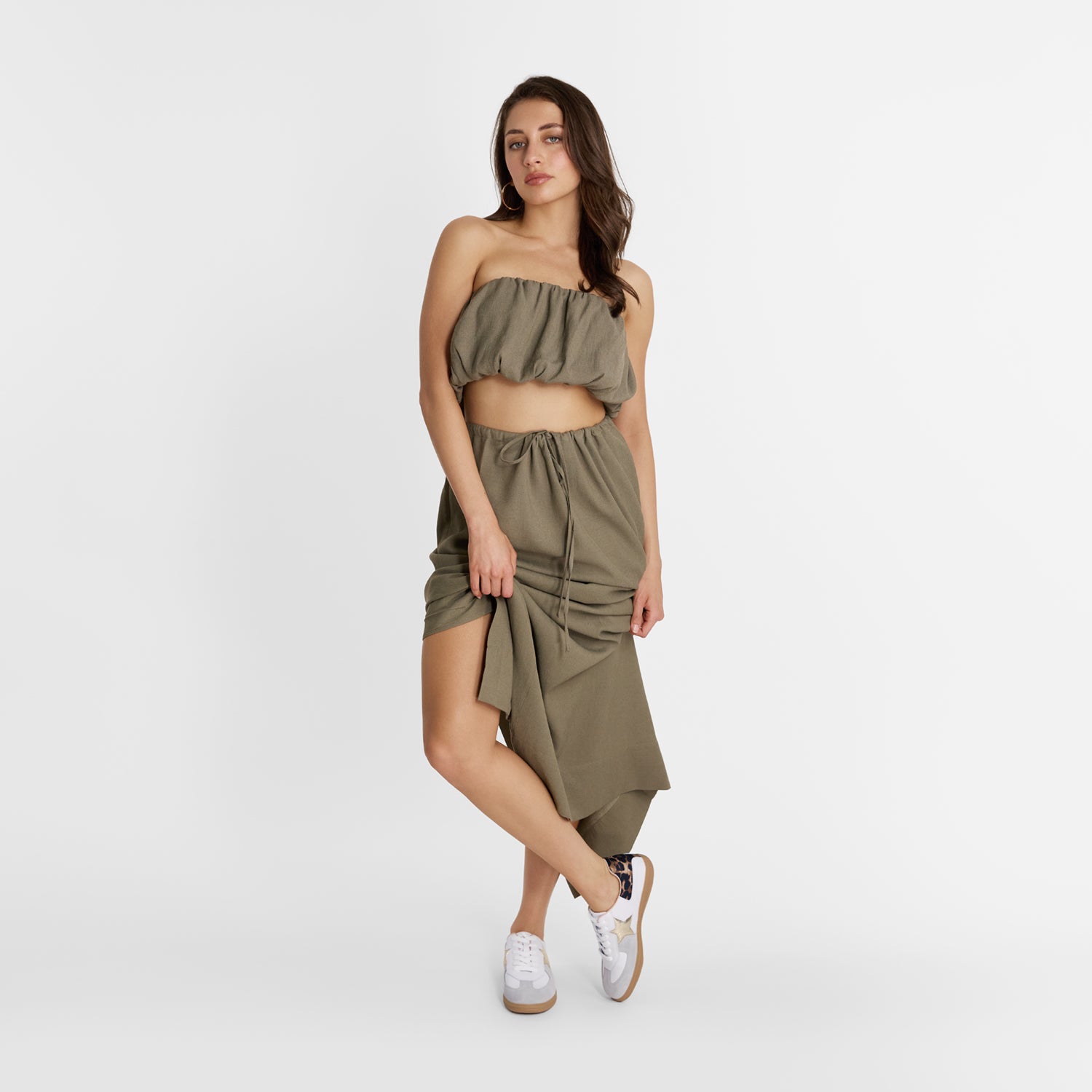 Woman wearing a green outfit with designer sneakers by Nicole Rebstock