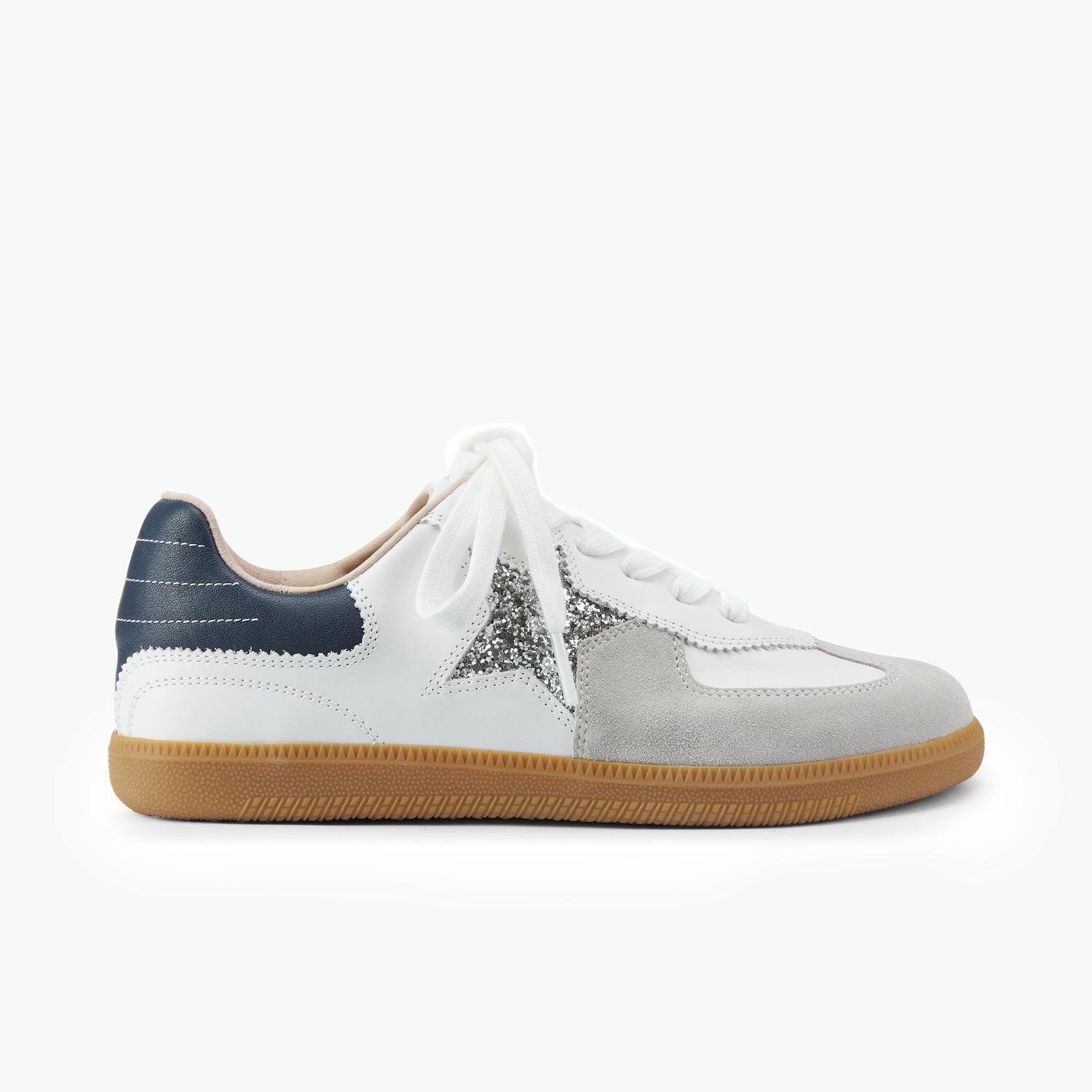 White lace-up leather sneaker with brown sole, silver glitter star and navy heel on a white background.