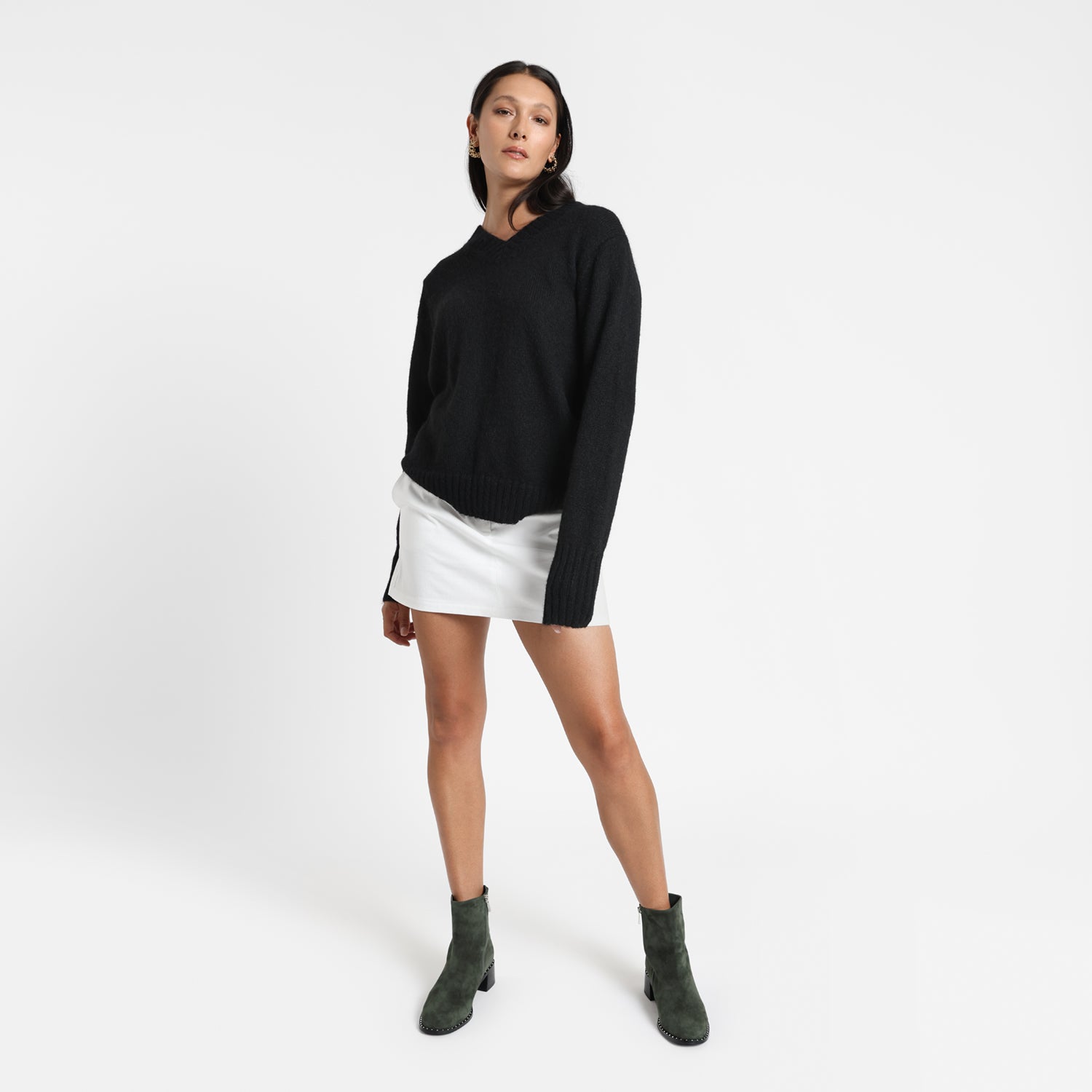 Bordeaux dark moss suede on model wearing white mini skirt and black pullover.