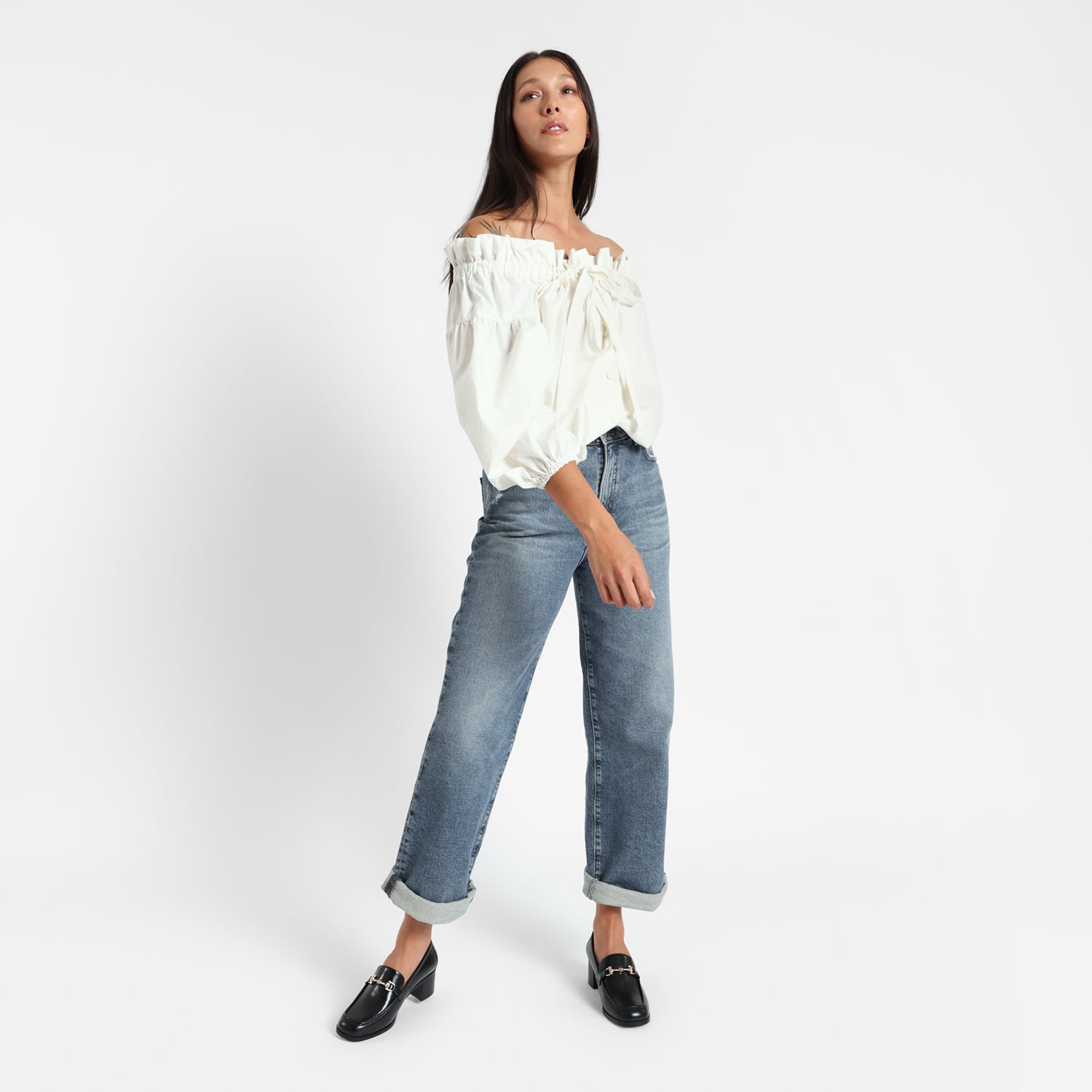 Bremen loafer in black leather worn by woman. Gold buckle. 4.5cm block heel.