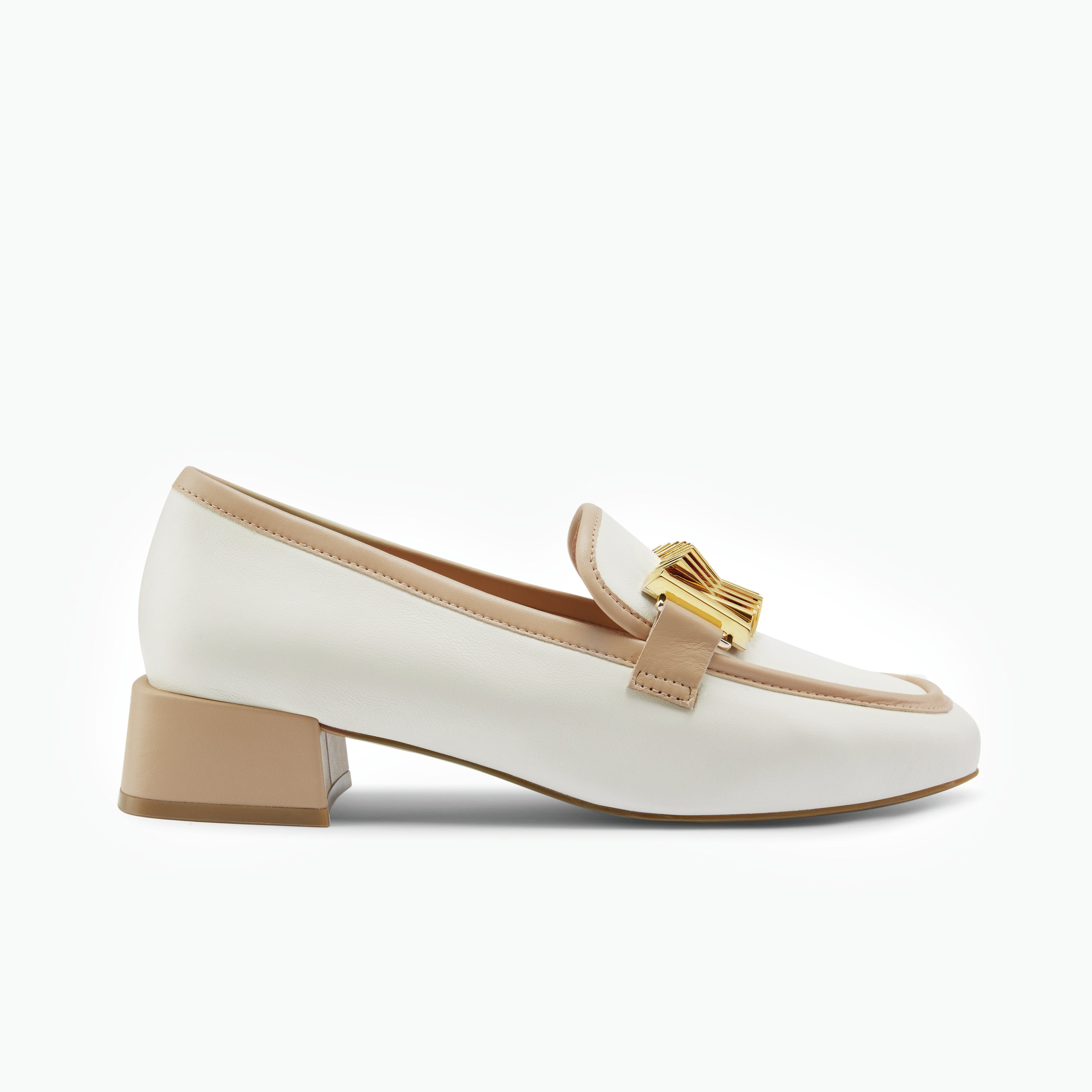 Cream Loafer shoe with nude heel and gold buckle on a white background. By Nicole Rebstock