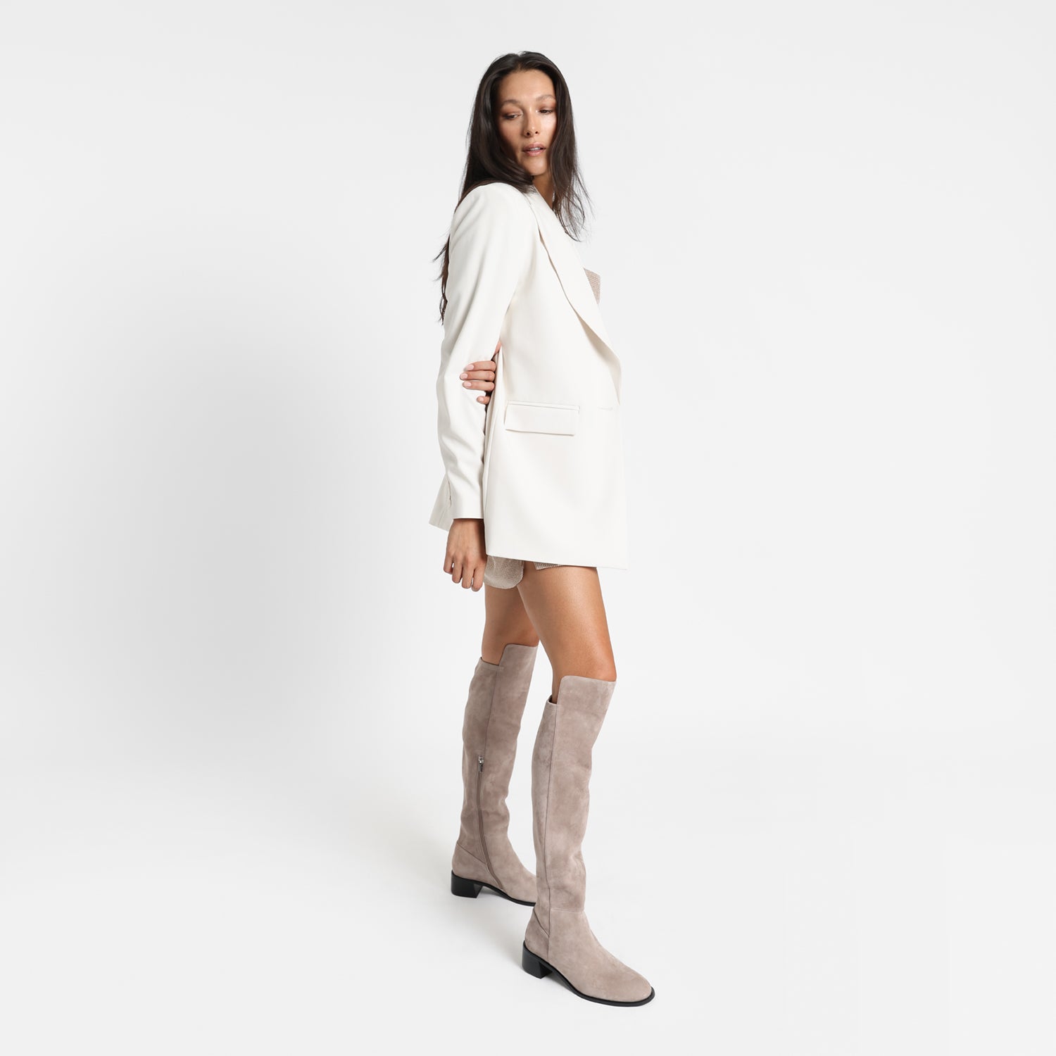 Knee high Brussels boot in Taupe with low block black heel. Worn by model.