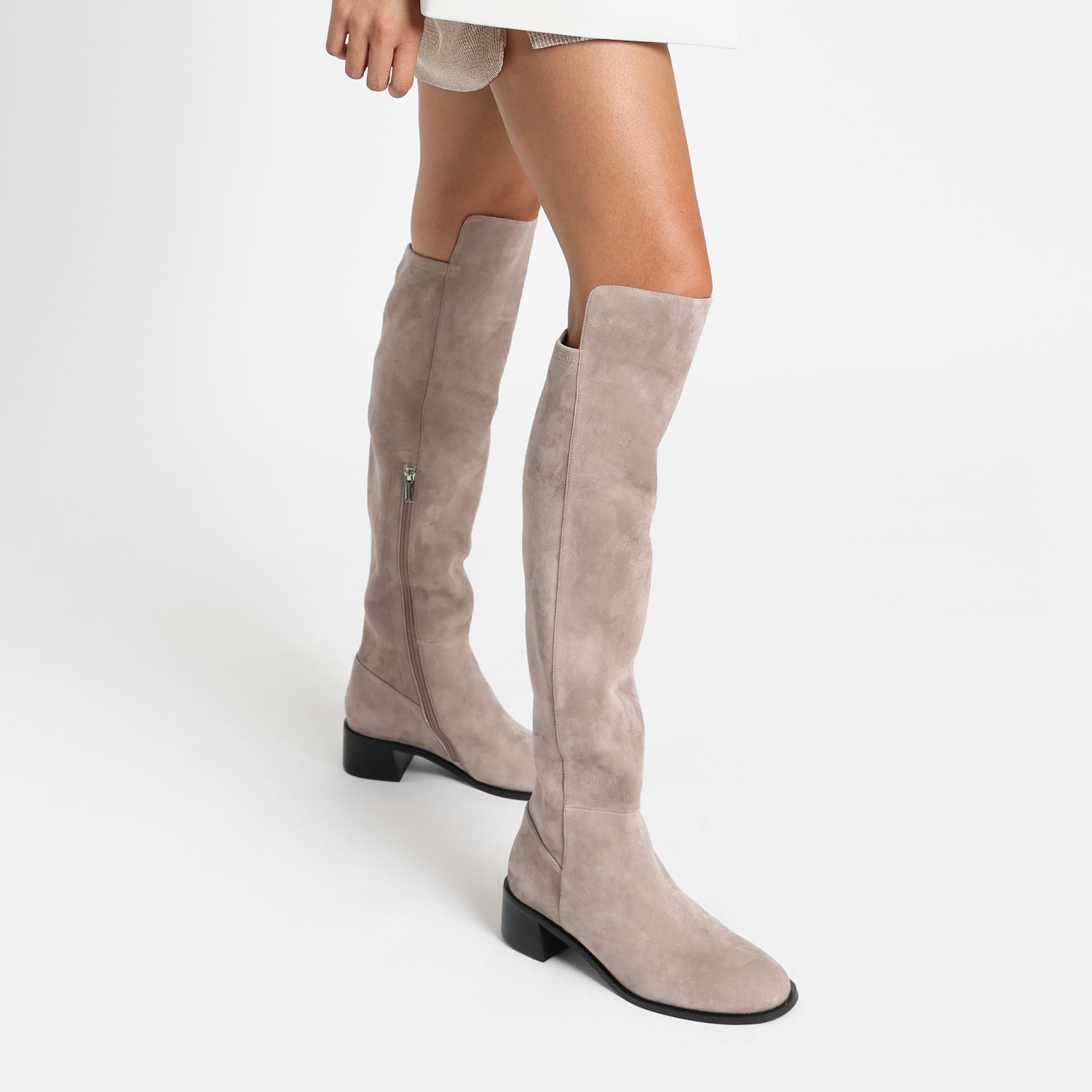 Brussels long boot in taupe suede. Close up view on woman.