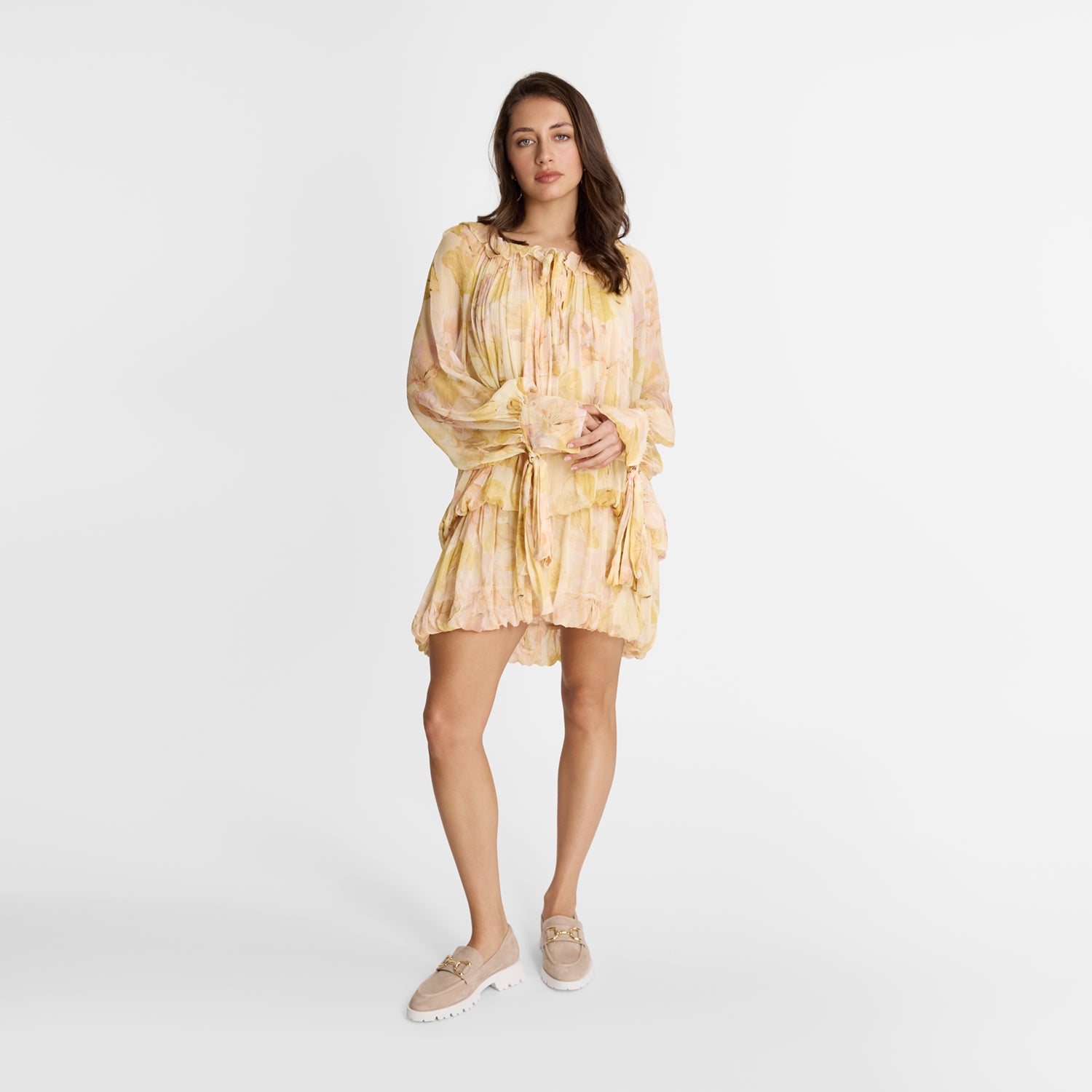 Woman wearing a yellow floral dress on a white background with Nicole Rebstock nude loafers