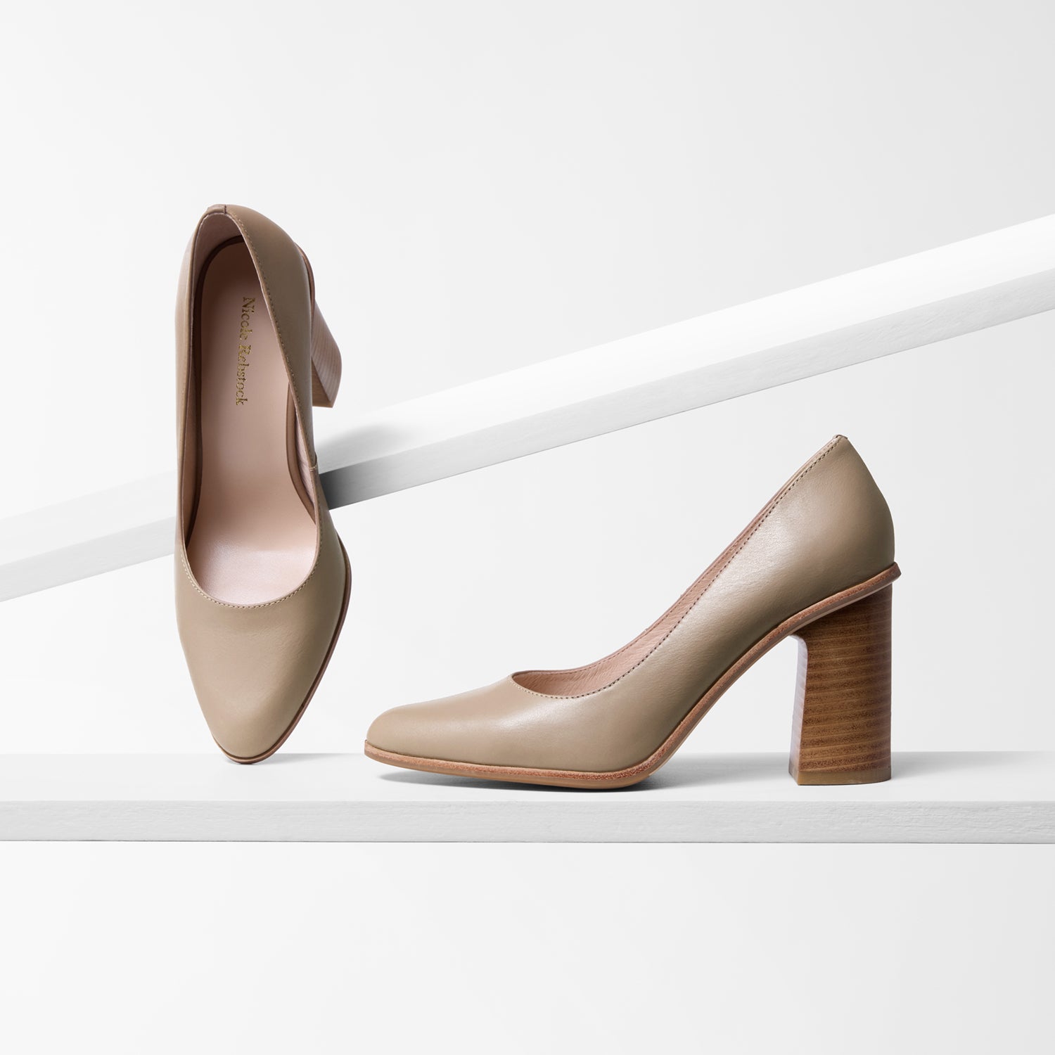 Pair of beige high-heeled shoes on a white background. 8.5cm block heel with almond toe.