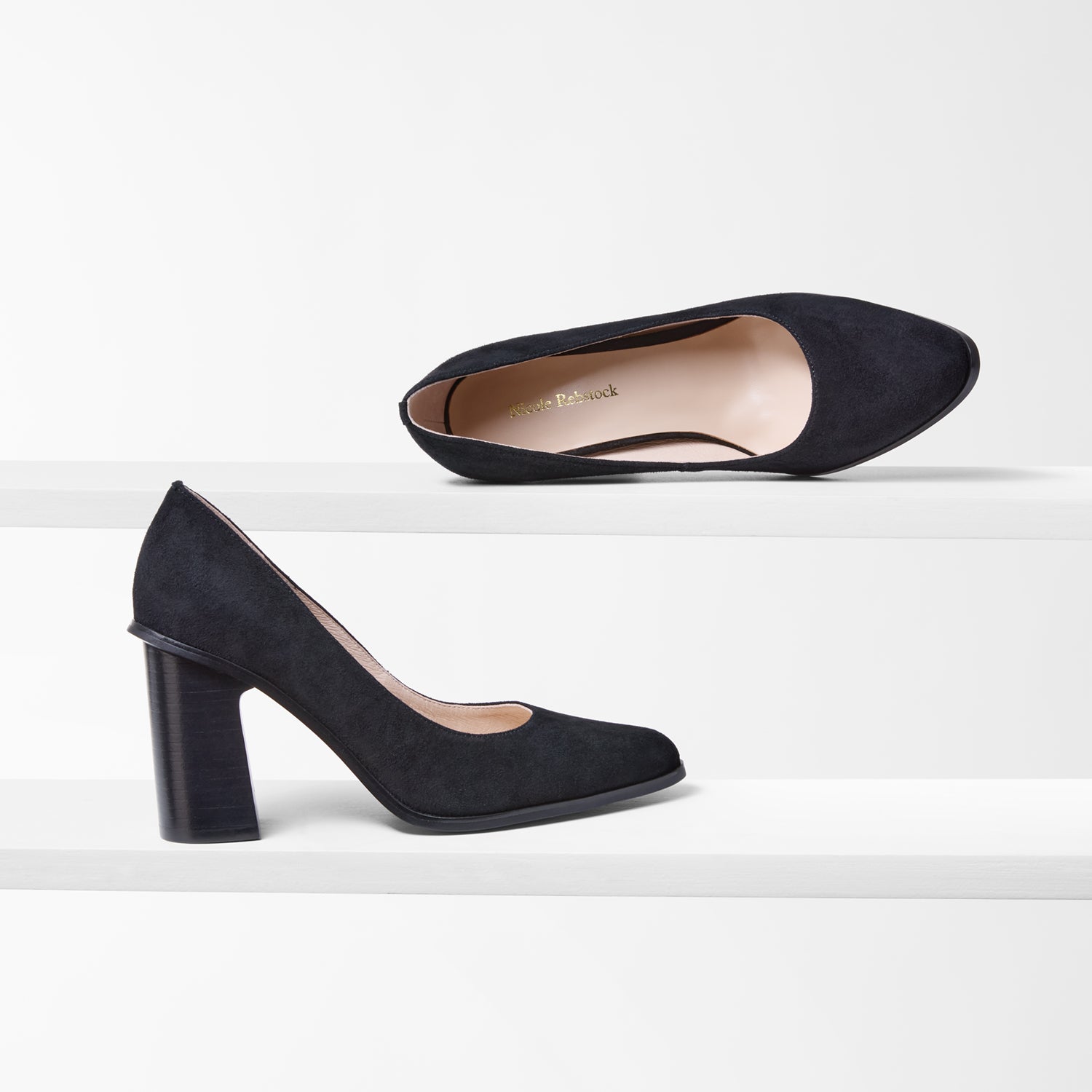 pair of black suede pumps with almond toe on white background