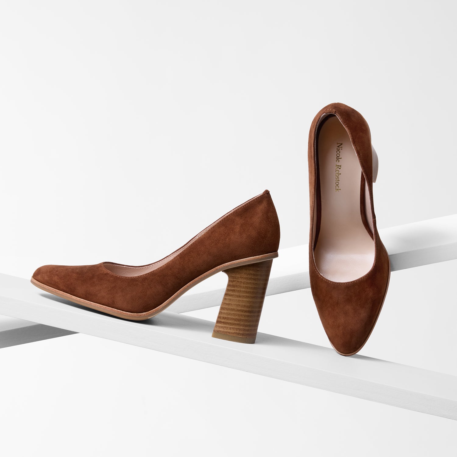 Pair of rust suede pumps with an almond toe called Cassie by Nicole Rebstock.