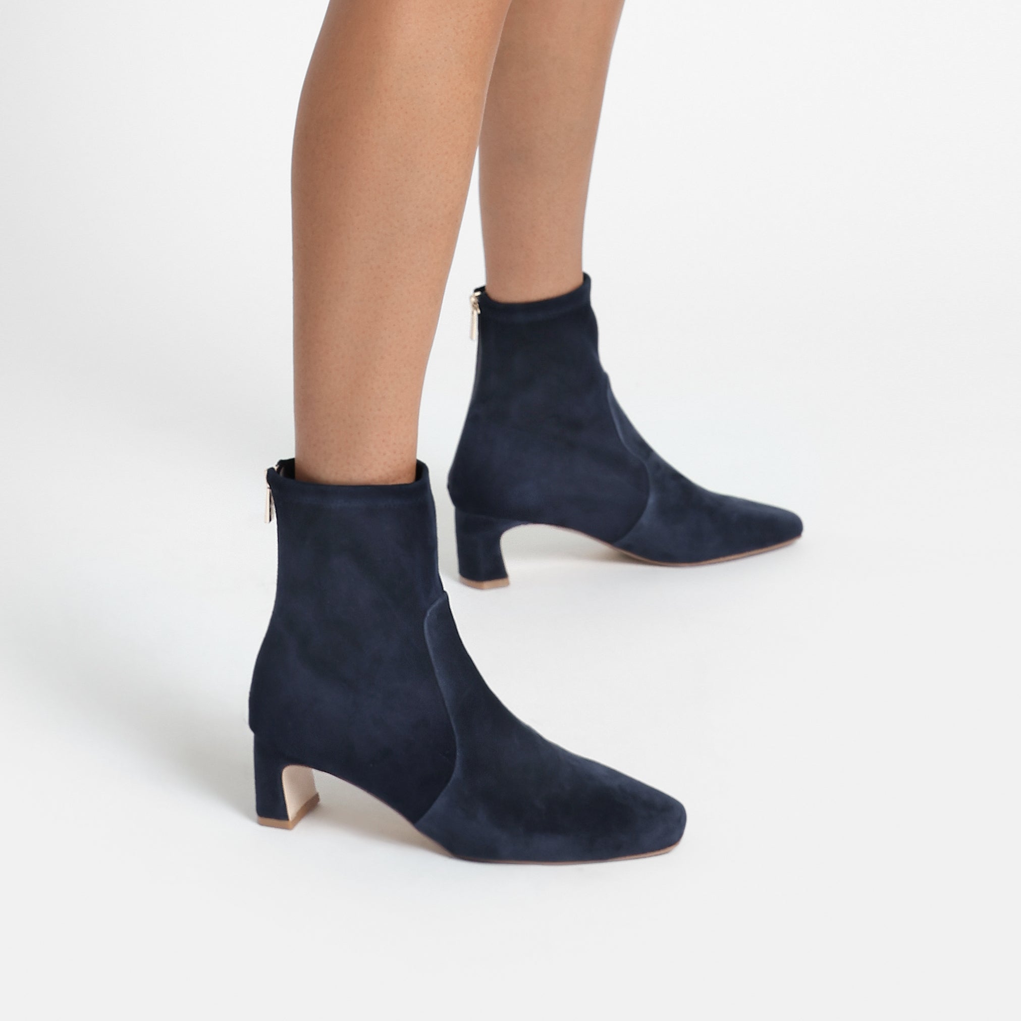Demi navy suede ankle boot with stretchy leather and square toe shown on women's feet.