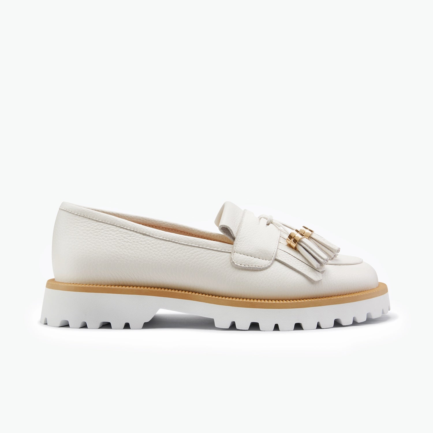 A single white leather loafer with a tassel detail and a chunky white lug sole, shown from a side profile on a clean white background.
