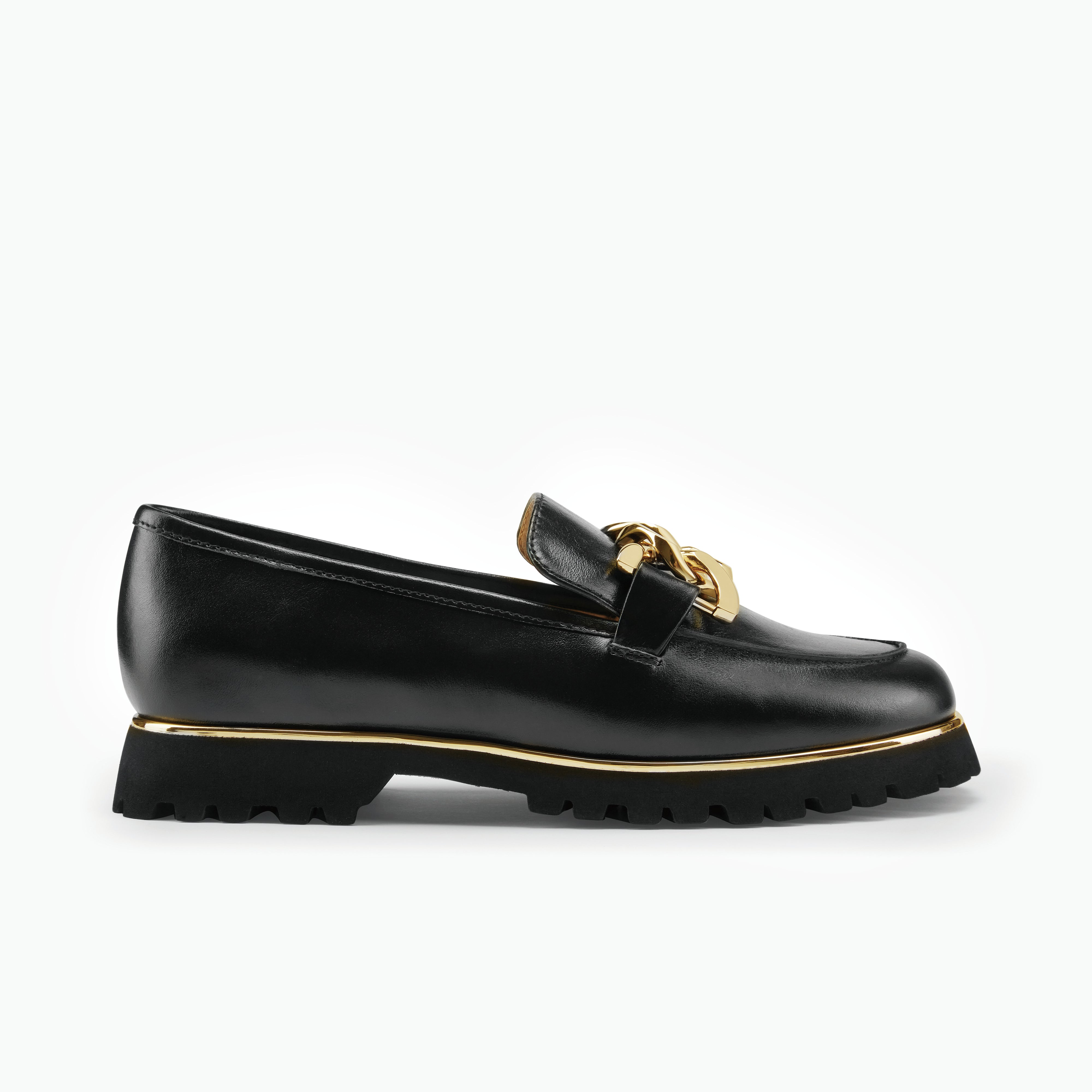 Black loafer with gold accents on a white background