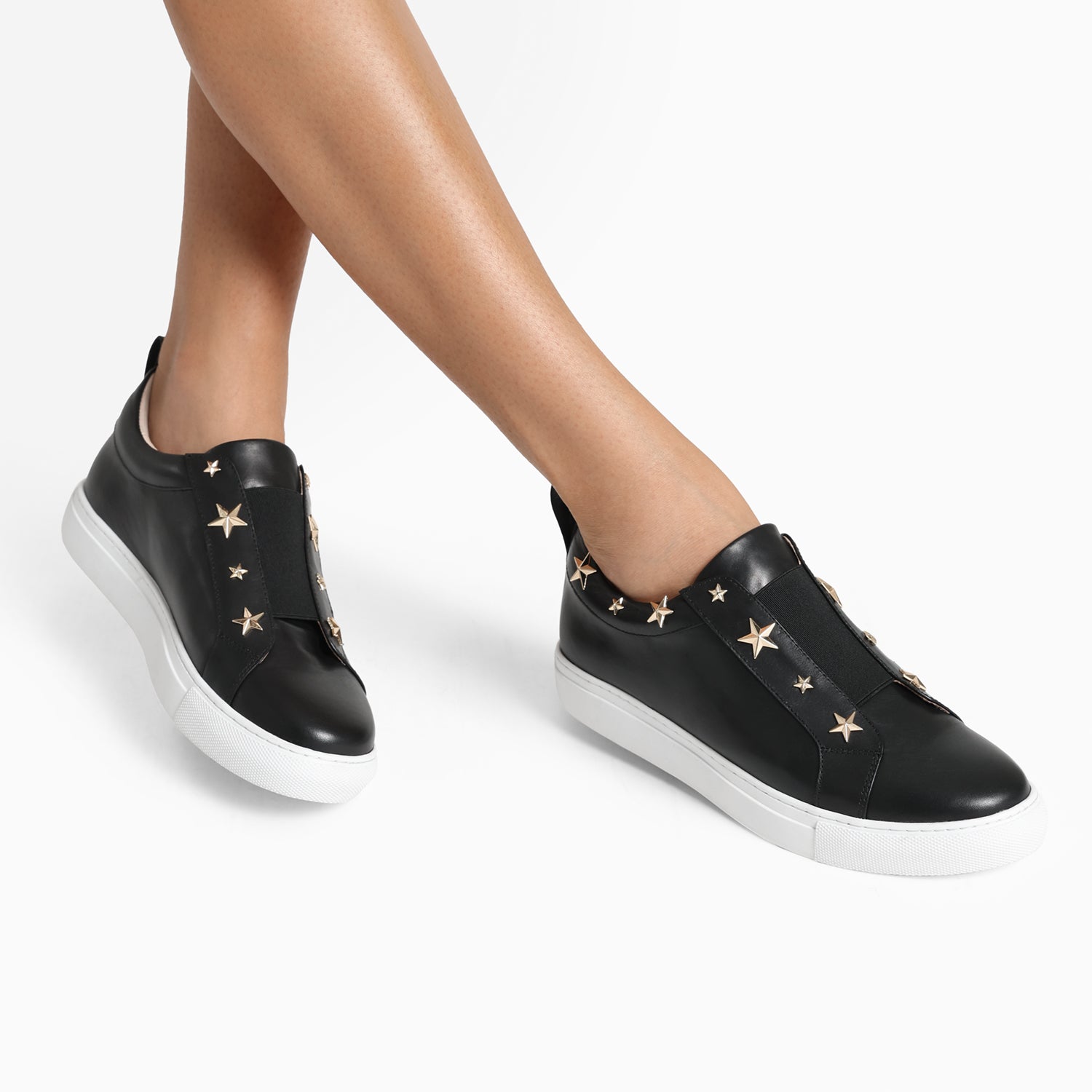 Felix black elasticated pull on leather sneaker with gold star studs around top line. Worn by model.