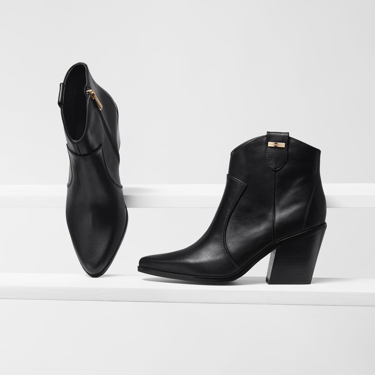 Black leather ankle boots on a white background with gold accents and block 8cm heel.