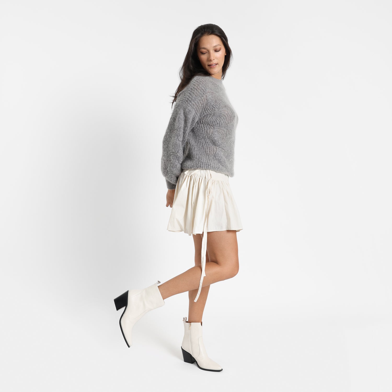 Frankin ivory ankle boot shown on model wearing a grey jumper and a white skirt.