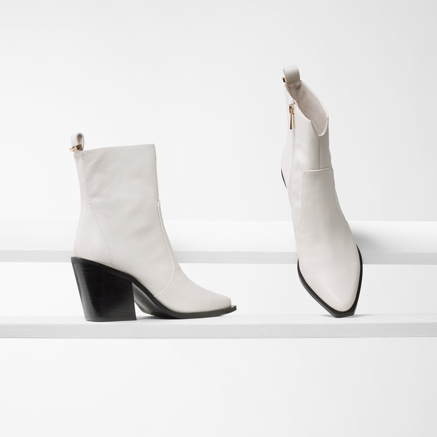 Franklin ivory leather ankle boots on planks showing all sides.
