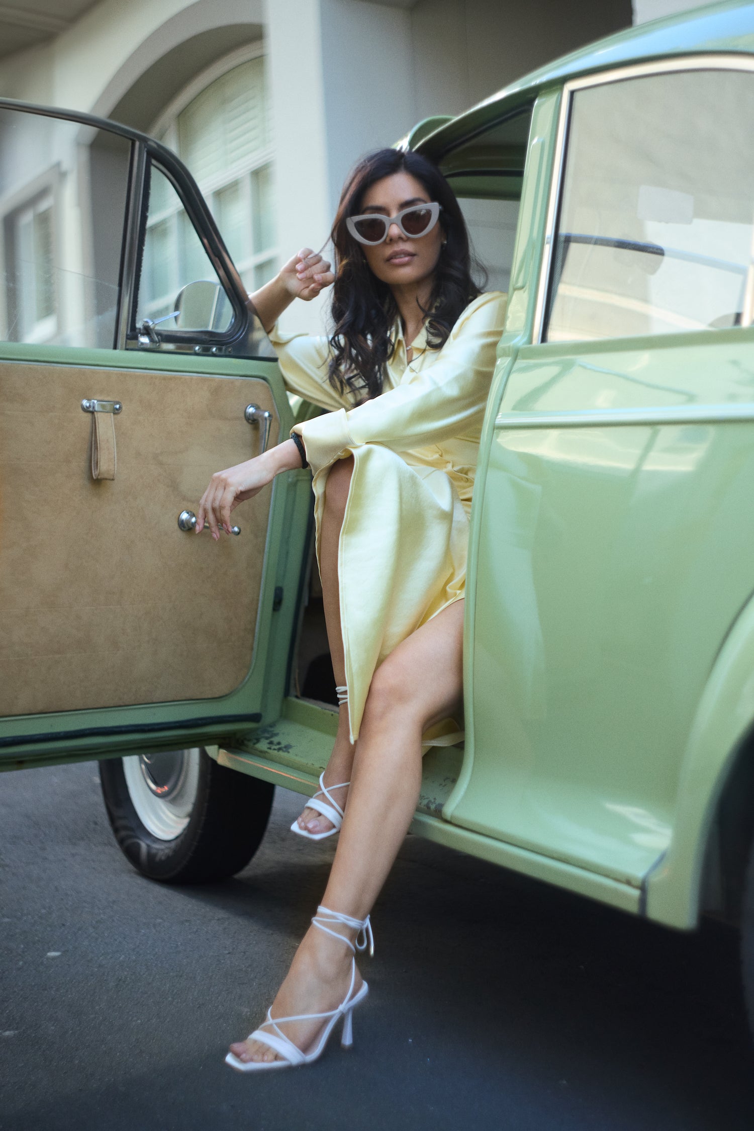 Gio white leather sandals worn by model stepping out of the car.