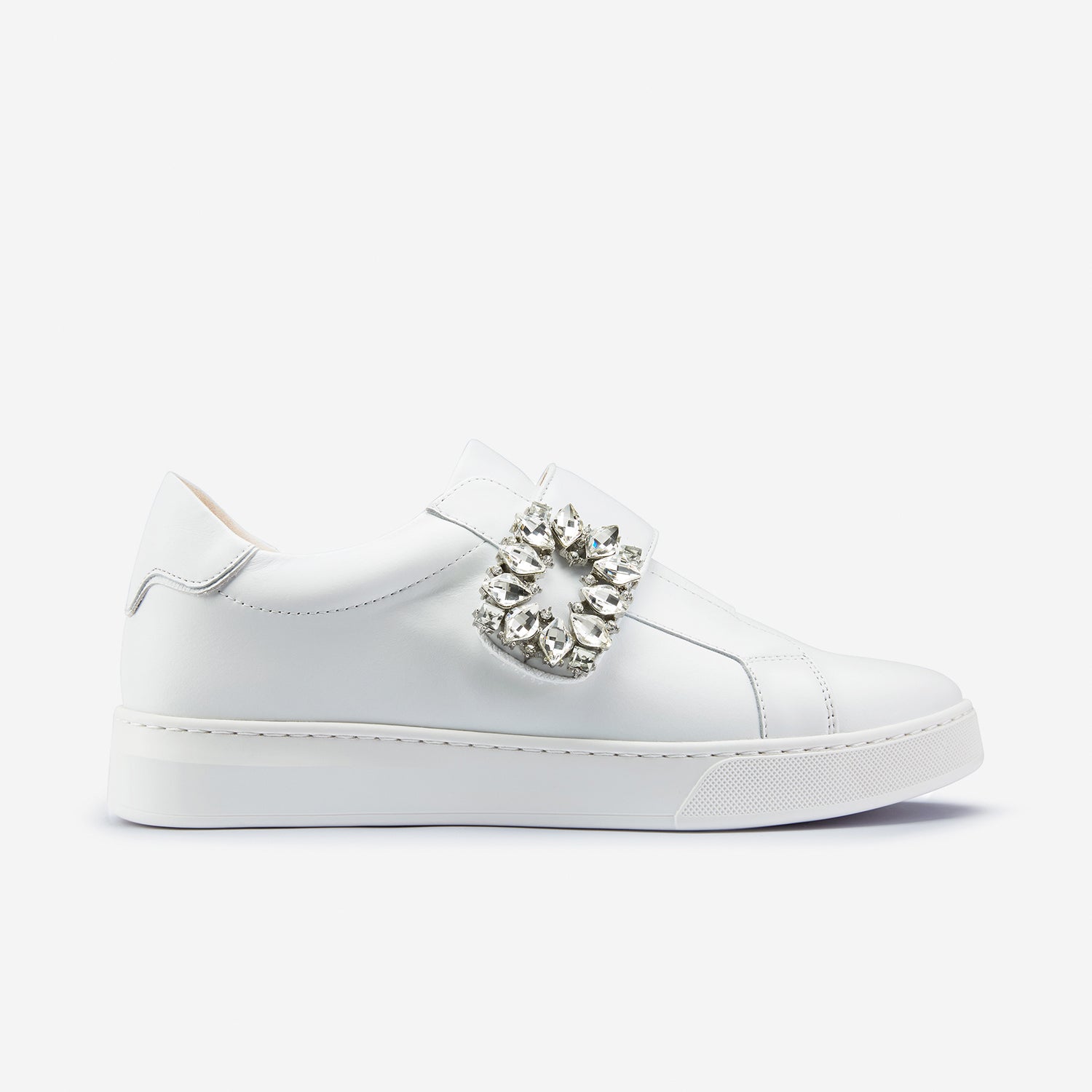 Gracie sneaker in white showing its side profile. They have a Velcro strap with silver embellishments.