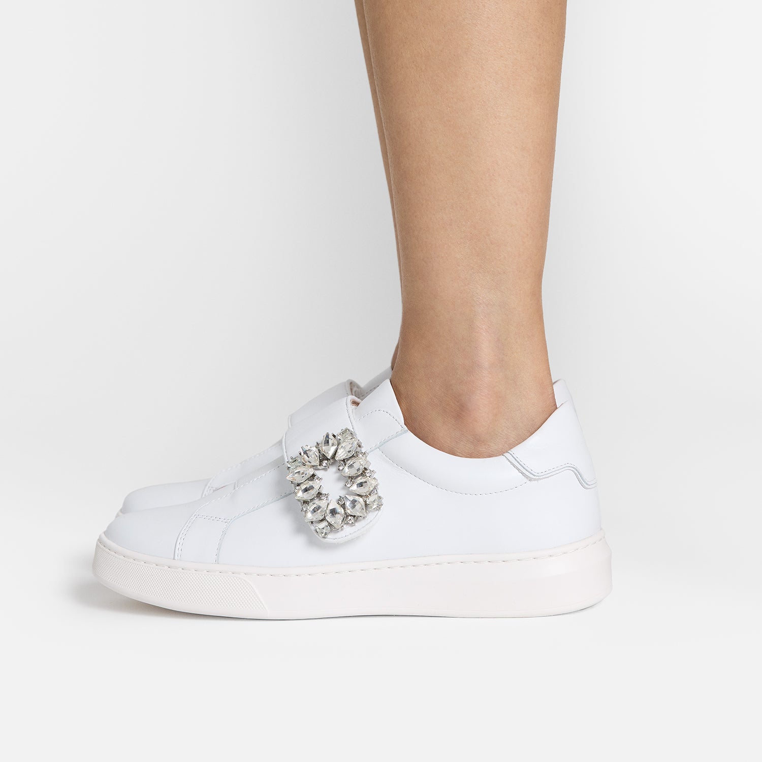 Model stands to side wearing limited edition capsule sneaker, Gracie.