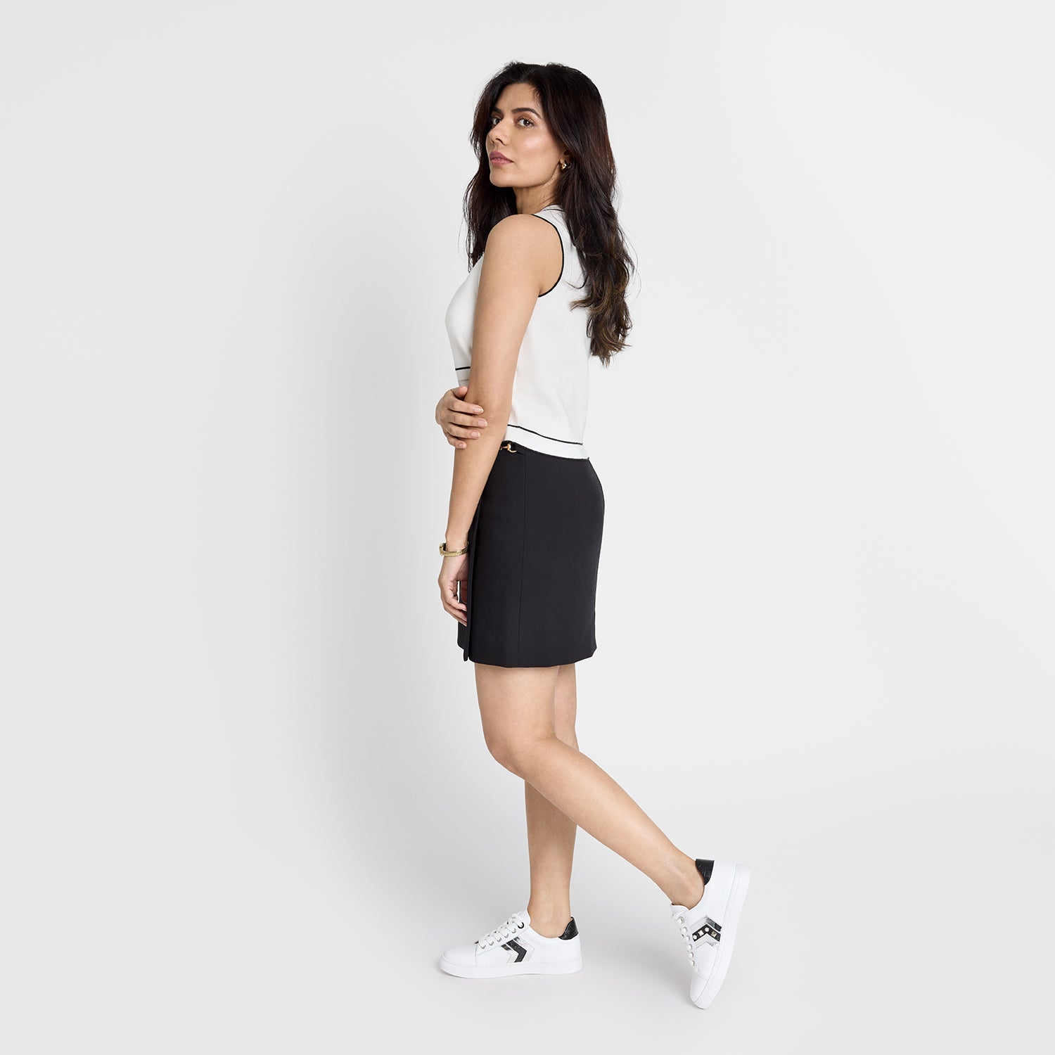 Model wearing gray sneaker with contrasting tones of black and silver.