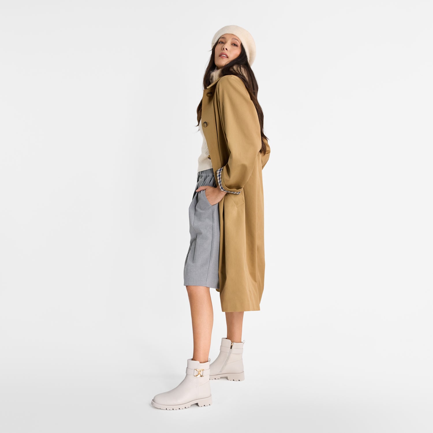 Woman modelling Nicole Rebstock ivory Jaso ankle boot with round toe and thick thread and gold detailing. Gold zipper.