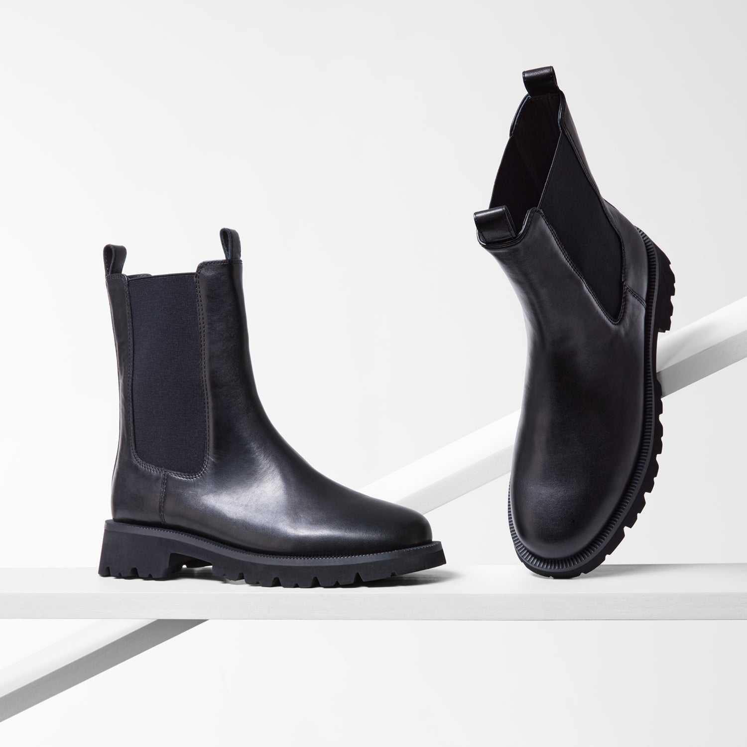 Black Chelsea boots with round toe on a white background