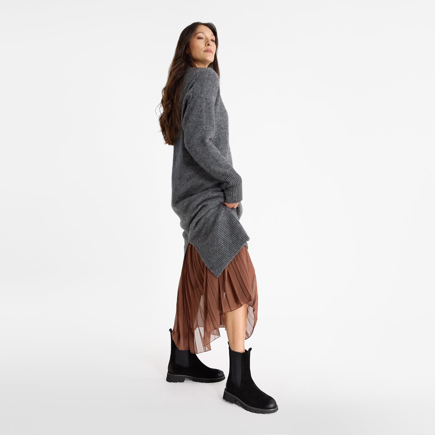 Woman wearing Nicole Rebstock's black suede Jax ankle boot with combat boot styling, tread and round toe.