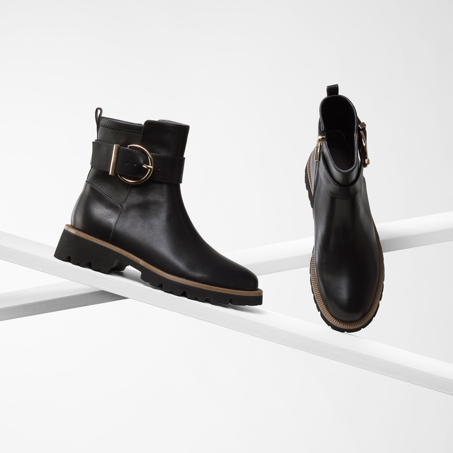 Jaxon black leather ankle boot with tan trim on planks showing all sides.