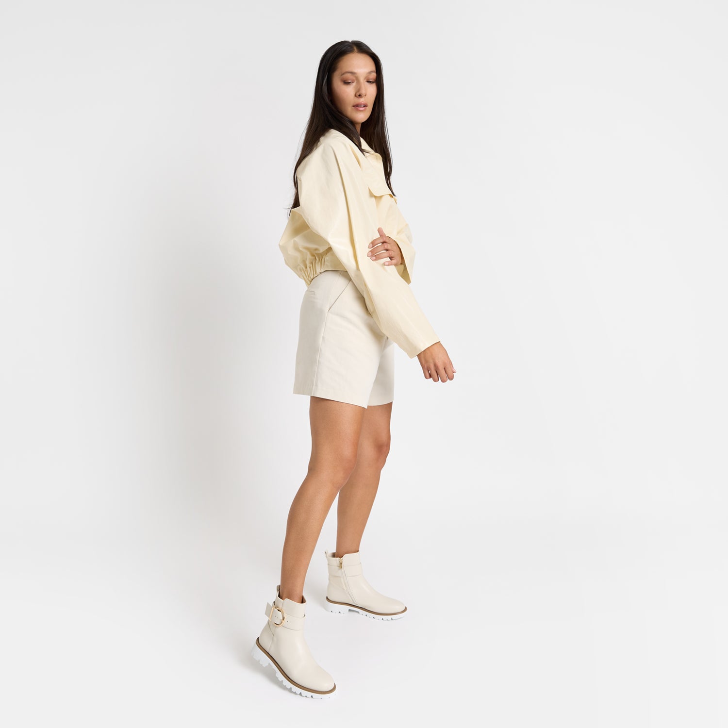 Jaxon ivory ankle boot on model wearing white shorts and a soft yellow bomber jacket.