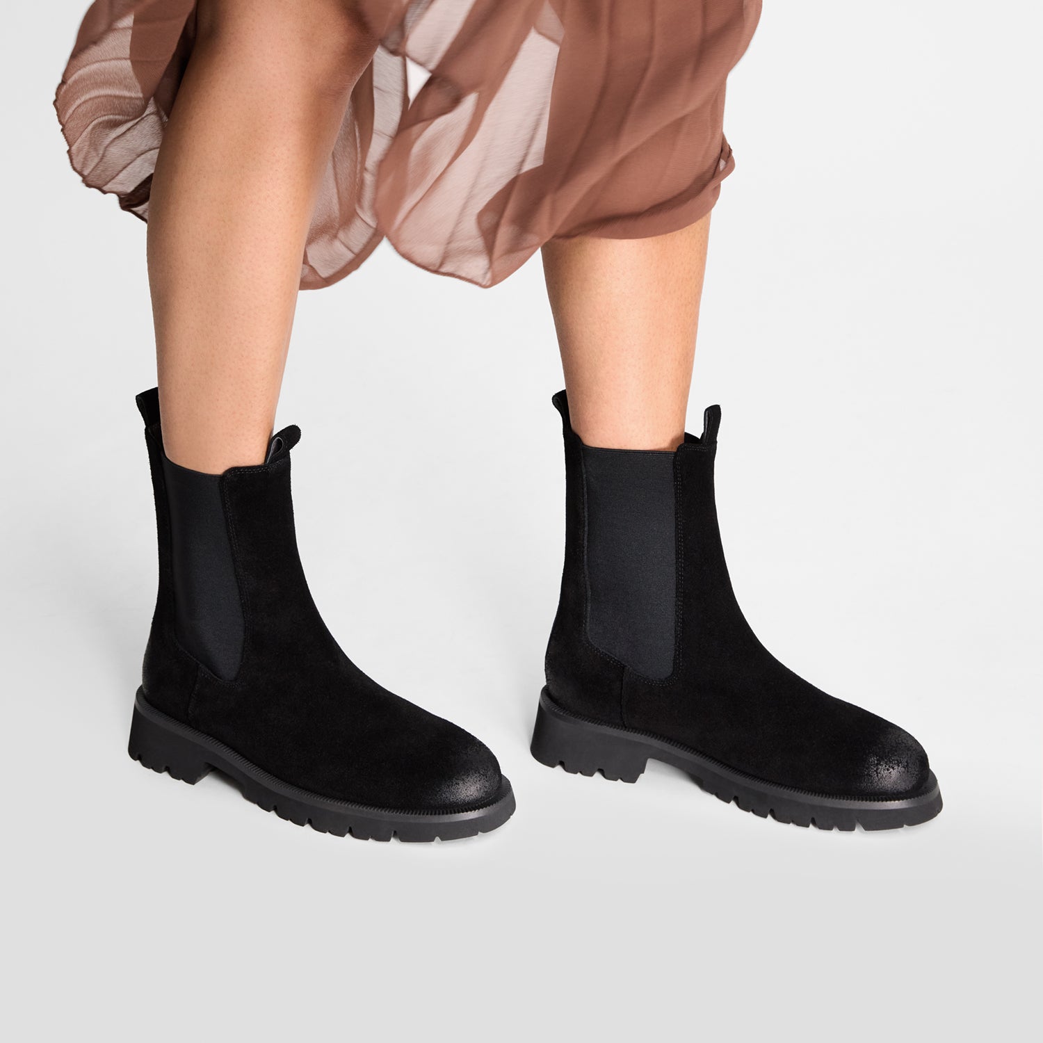 Flat Black suede chelsea boot on model. close up.