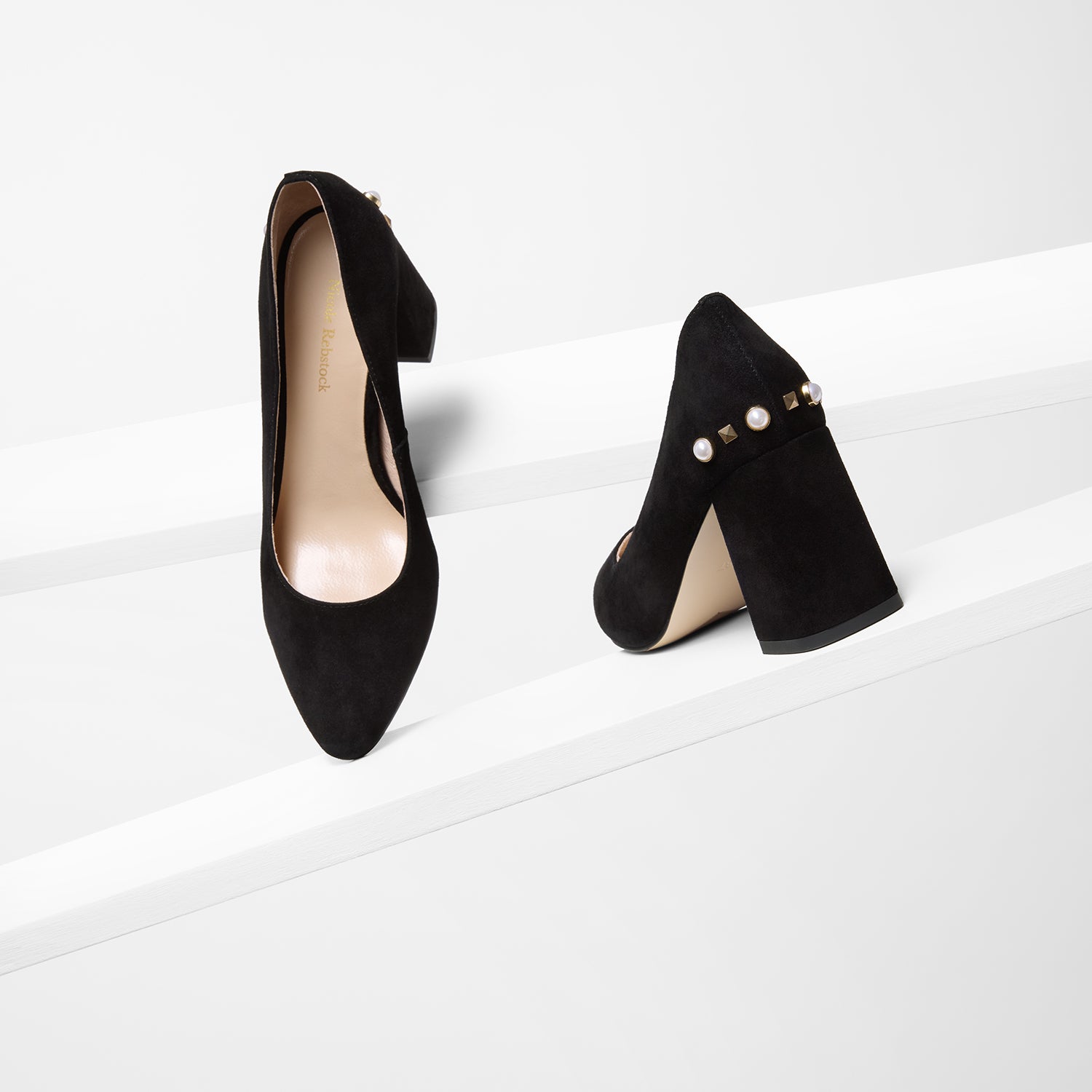 Jen black heel on planks showing all sides. They have a black suede leather upper and gold and pearl details.