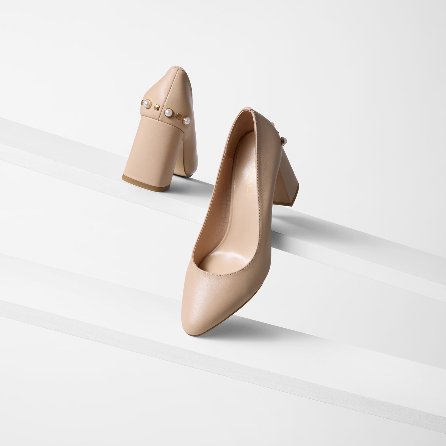 Jen heels in nude leather shown from all angles on planks. They have alternating gold and pearl stud details.