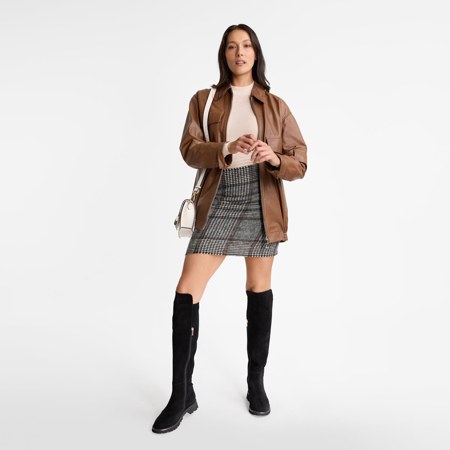 Model wearing Nicole Rebstock's stretch-fit black suede long boots that go over the knee with a zip and round toe.