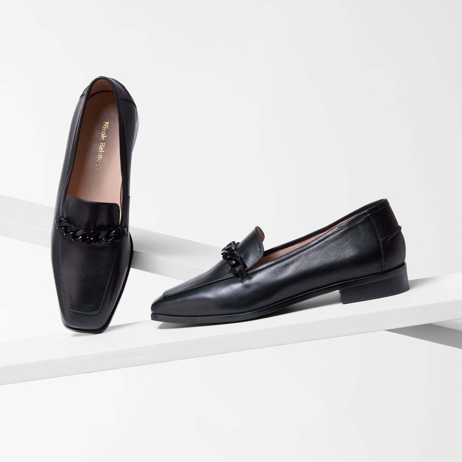 Pair of black loafers on a white background