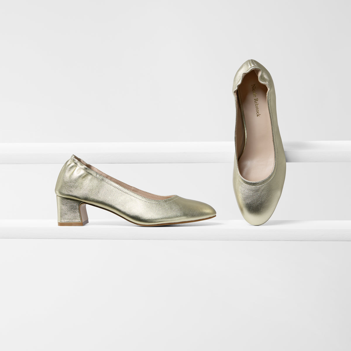 Gold pumps with an almond toe and medium block heel with elastic counter.