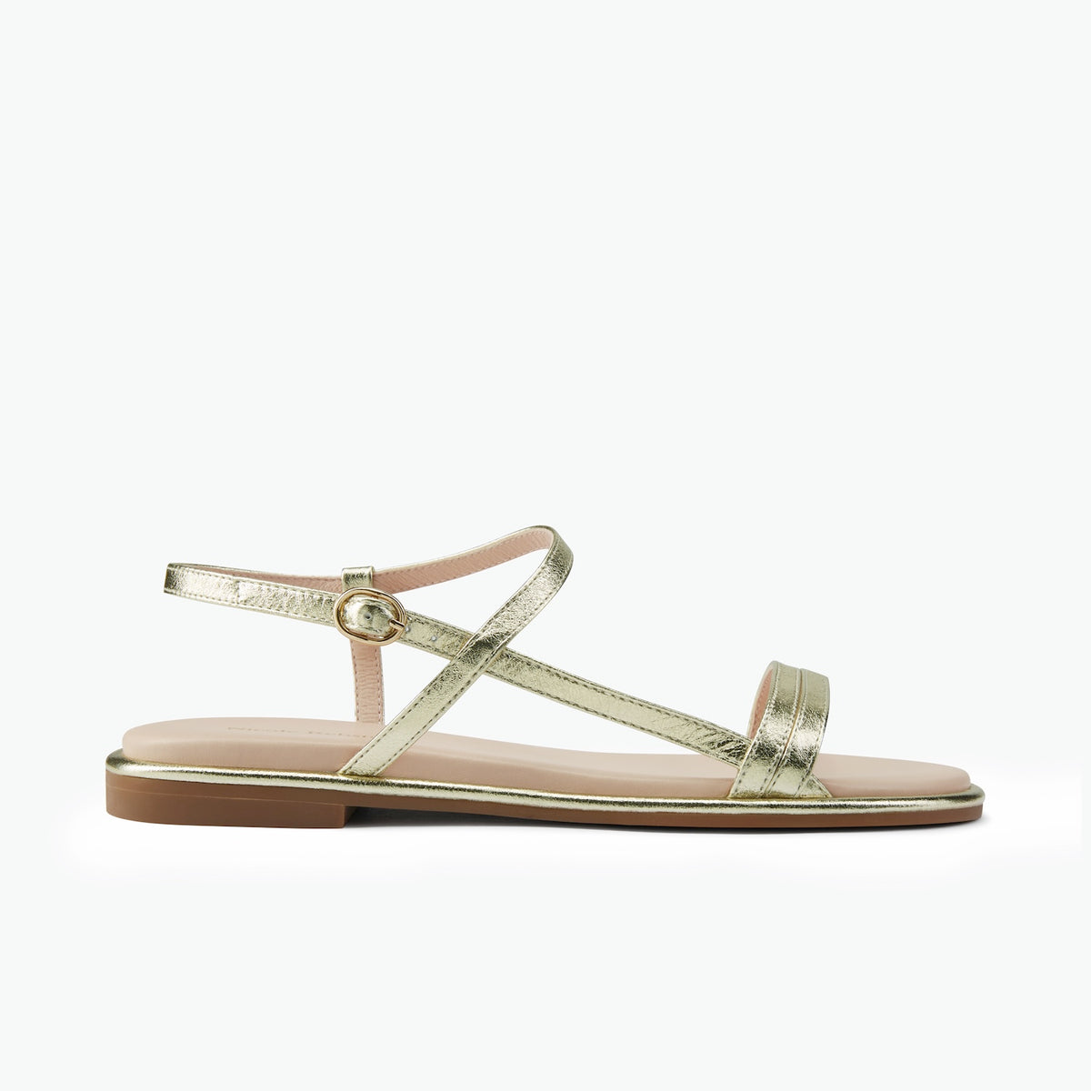 A single metallic gold flat sandal with a beige footbed and a brown sole, shown from a side profile on a light gray background.