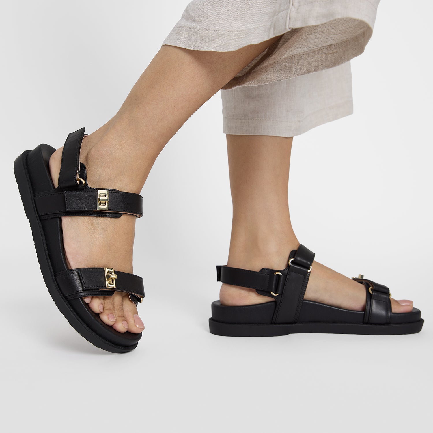 Close up shot of woman wearing black flat sandals called Maine.