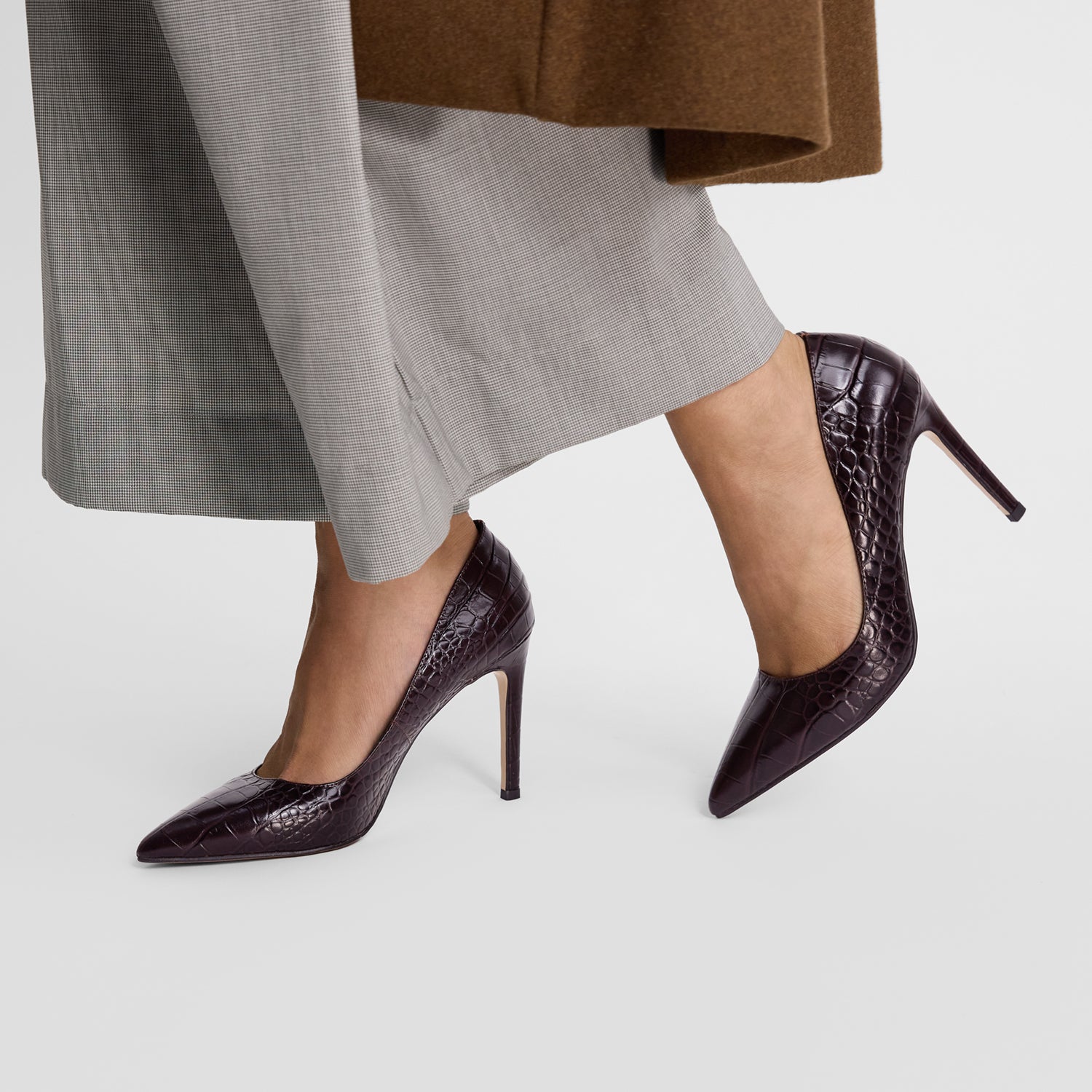 Nicole Rebstock's brown chocolate embossed pumps worn by a model up close.