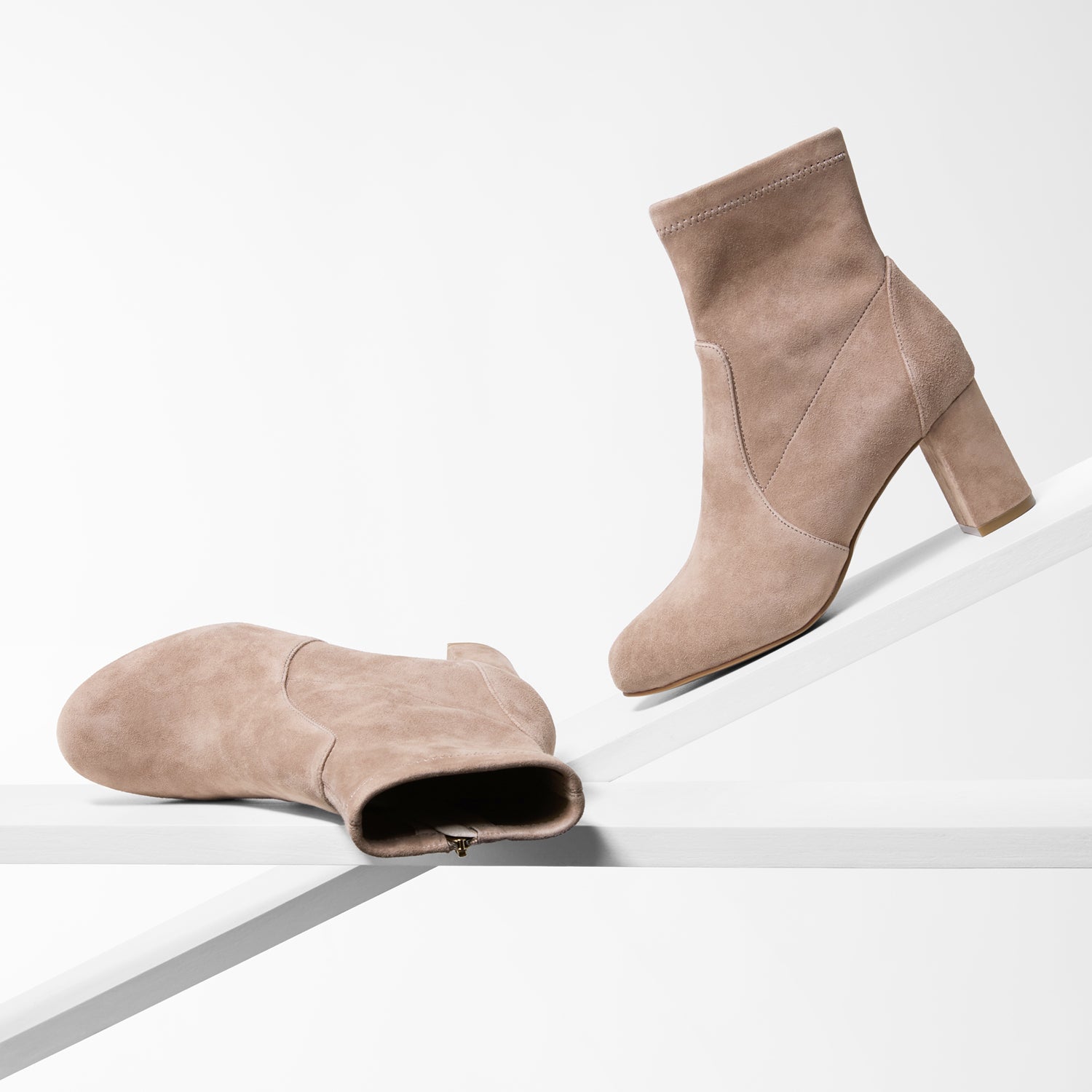 Pair of beige ankle boots on a white background
