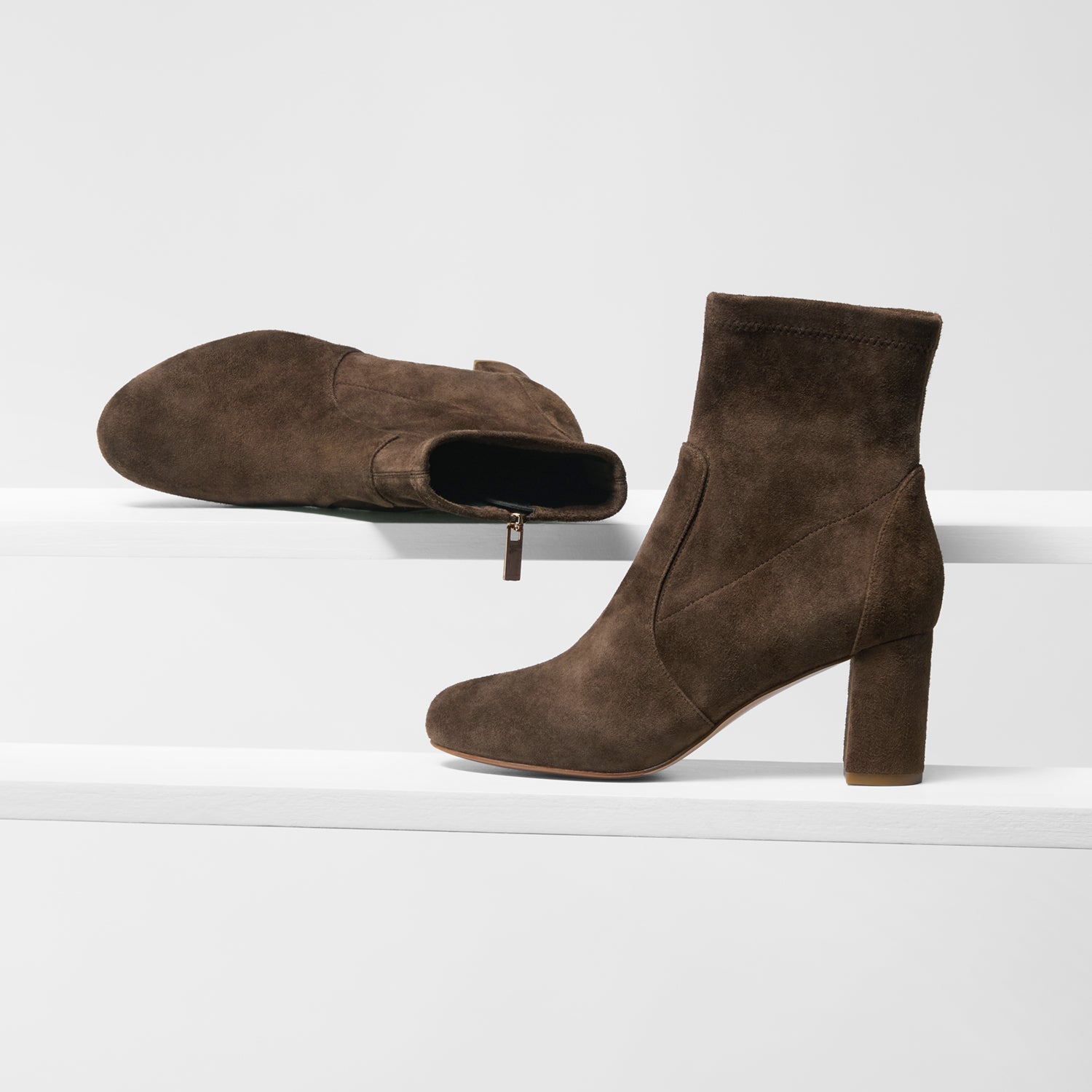 Brown suede ankle boots on a white background