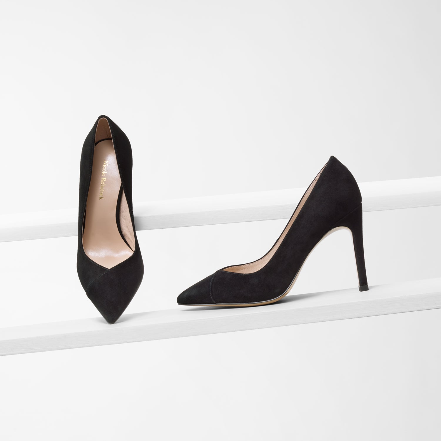 Naples black suede court shoes on planks showing v-cut top line and pointed toe.