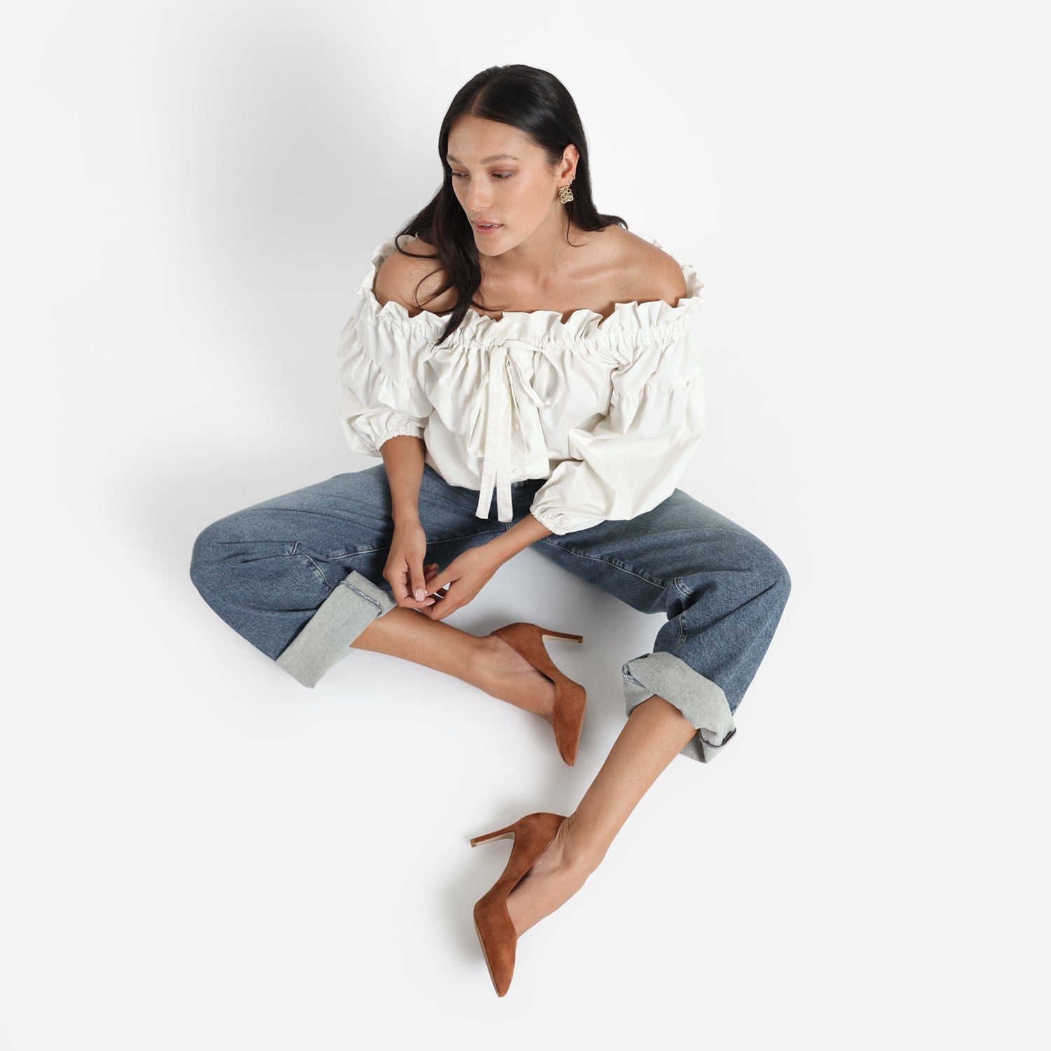 Model is wearing Nemesis rust sitting on the ground showing the heels.