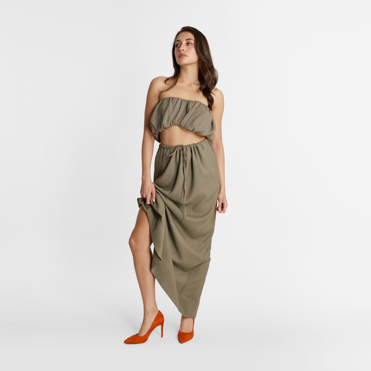 Model wears orange suede high heel pumps by Nicole Rebstock.