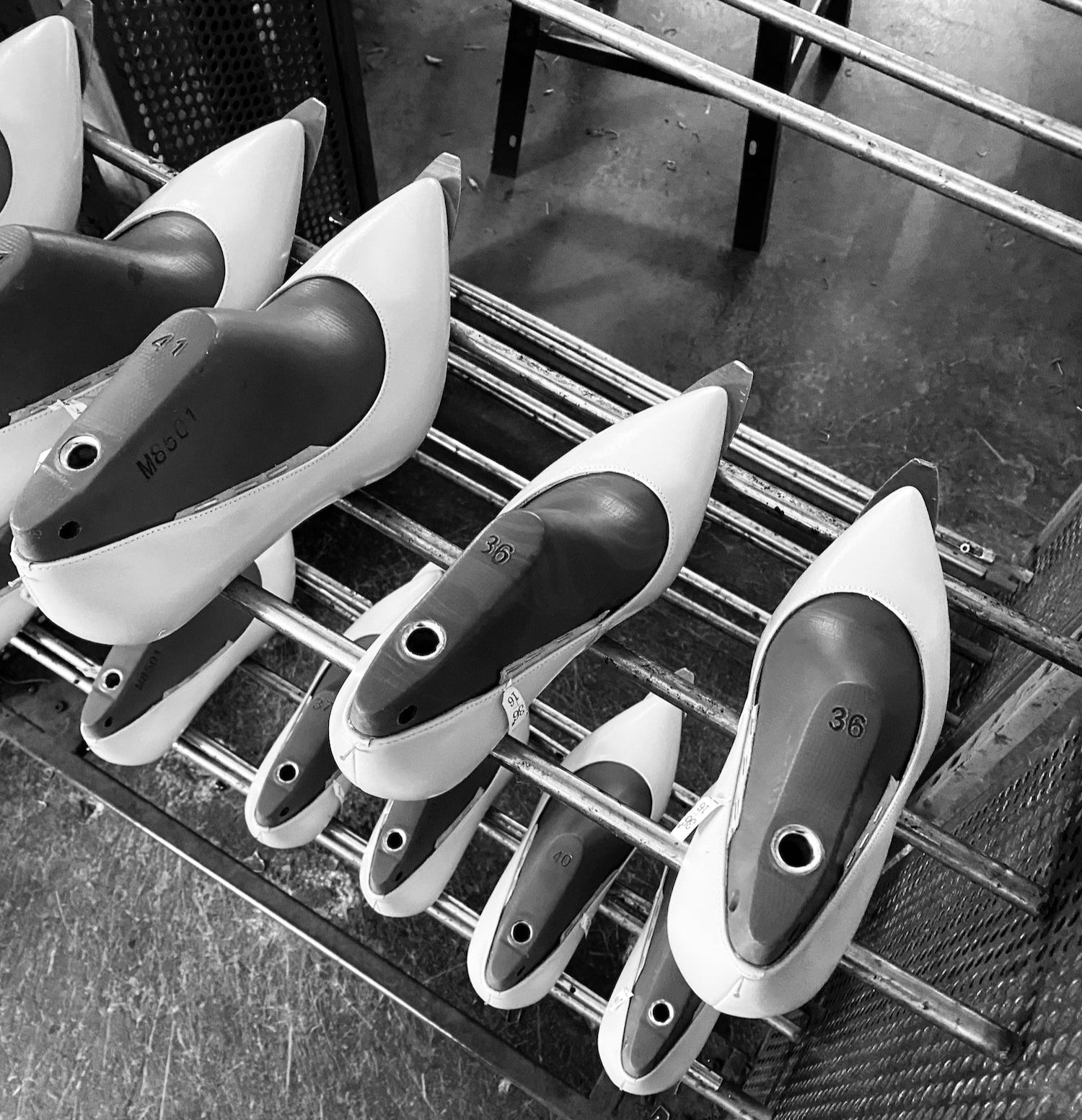 Set of shoe lasts on a metal rack with a black and white color scheme.