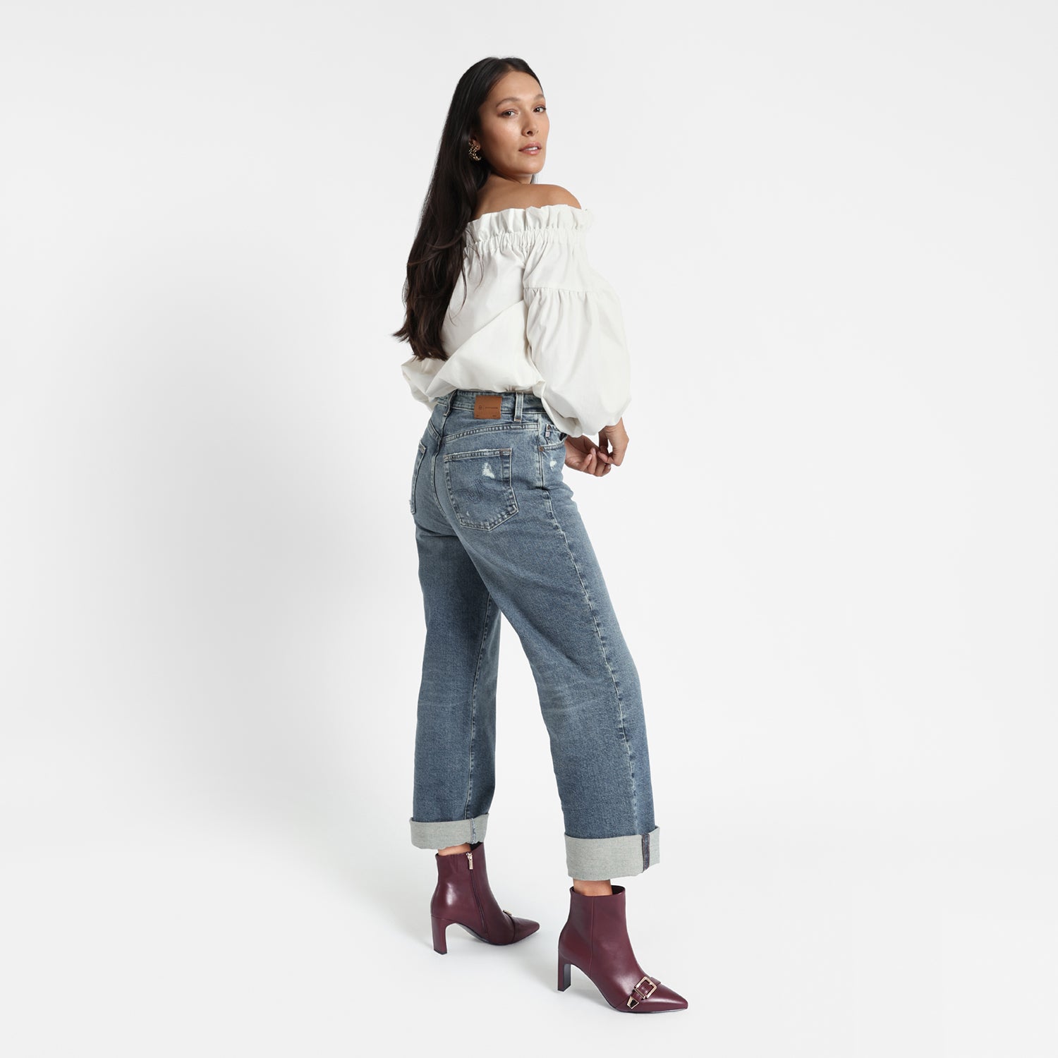 Rome ankle boot worn by model. The boot has a rectangular block heel, gold buckles and 7.5cm heel.