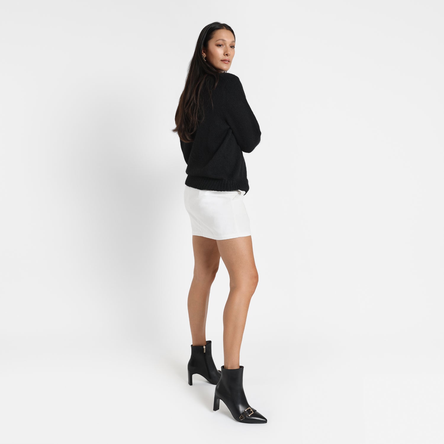Women wears black Rome Ankle Boots. They have a rectangle block heel which looks slim from the side and pointed toes with buckles on the toes. The heels are 7.5cm.