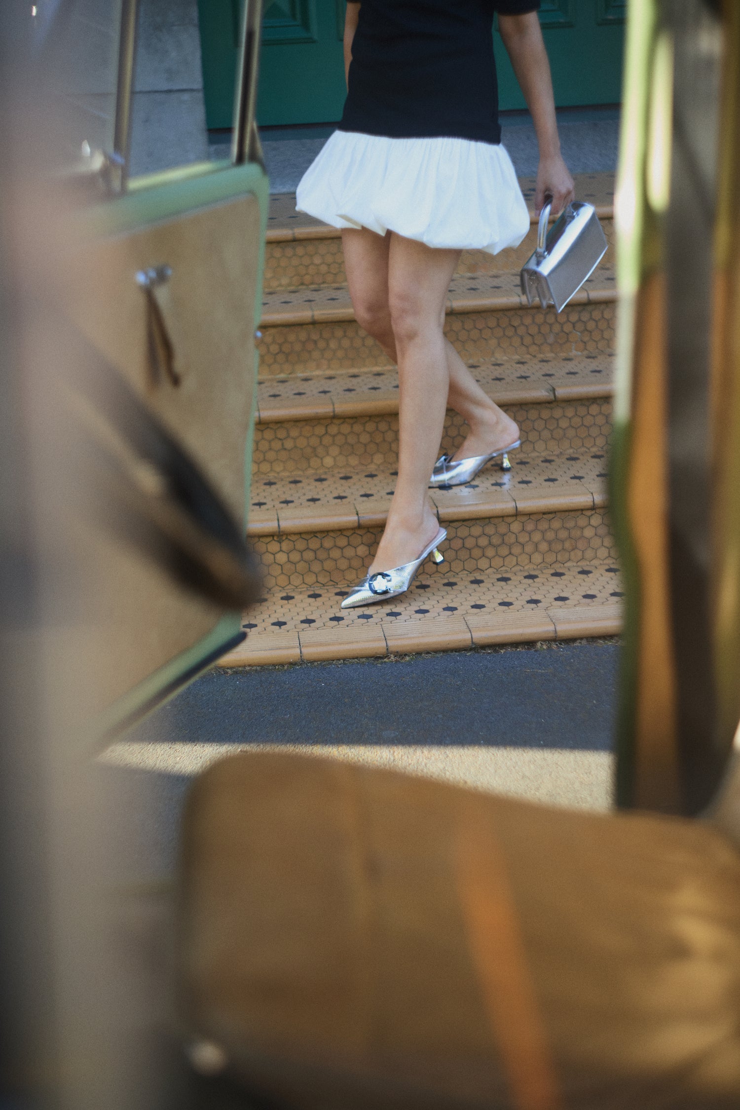 A campaign shot showing model wearing Sandro heel. They are disco ball silver with a v-cut top line.