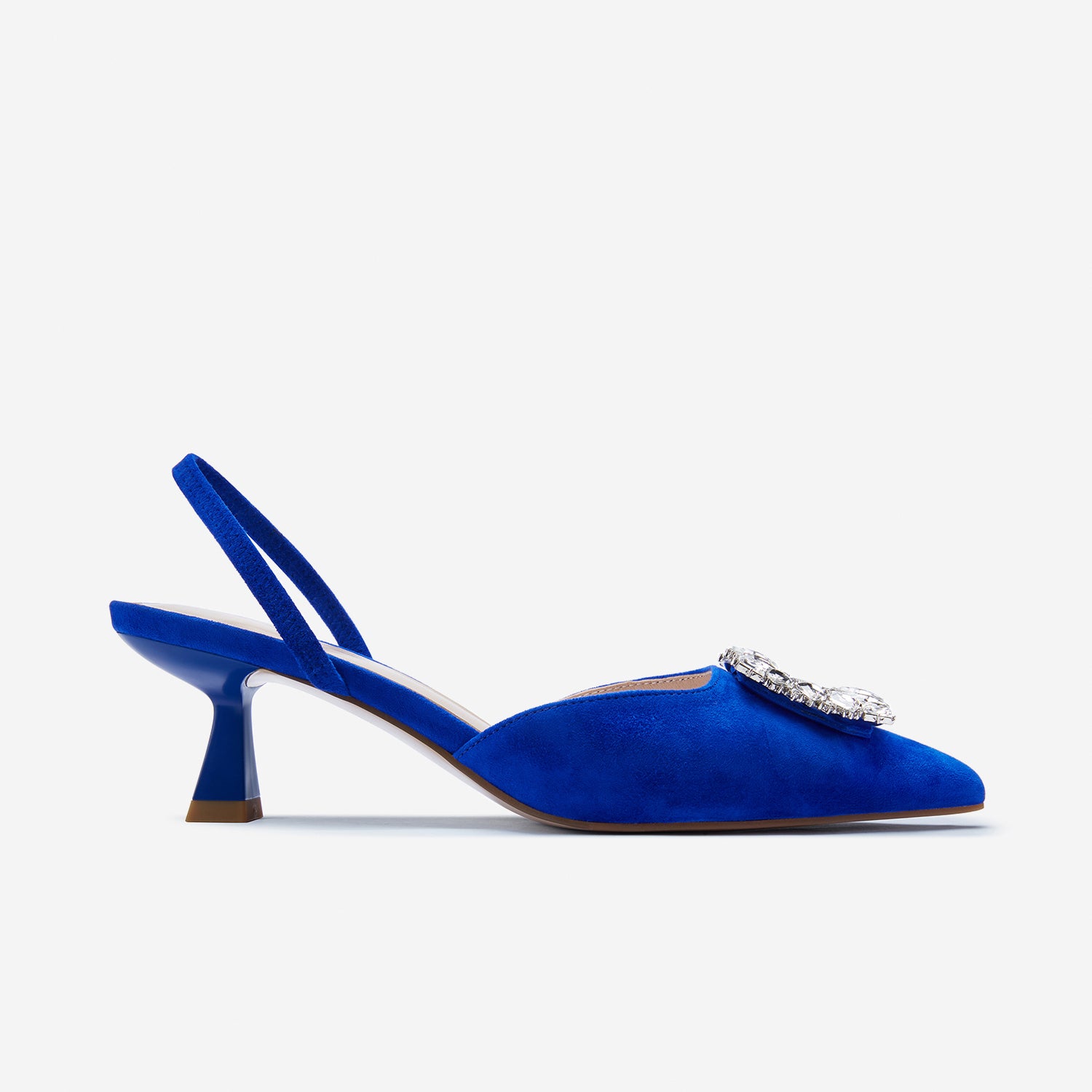 Clear side view of Sasha slingback heels. The cobalt blue suede also has diamond encrusted hardware detail.