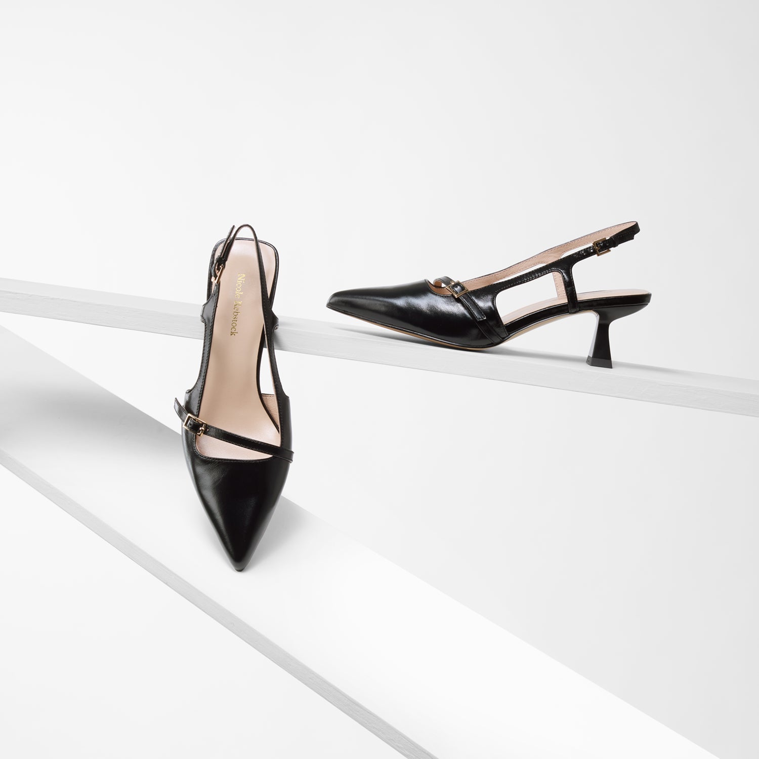 Sevilla pointed toe black oiled leather slingbacks on planks showing all angles.
