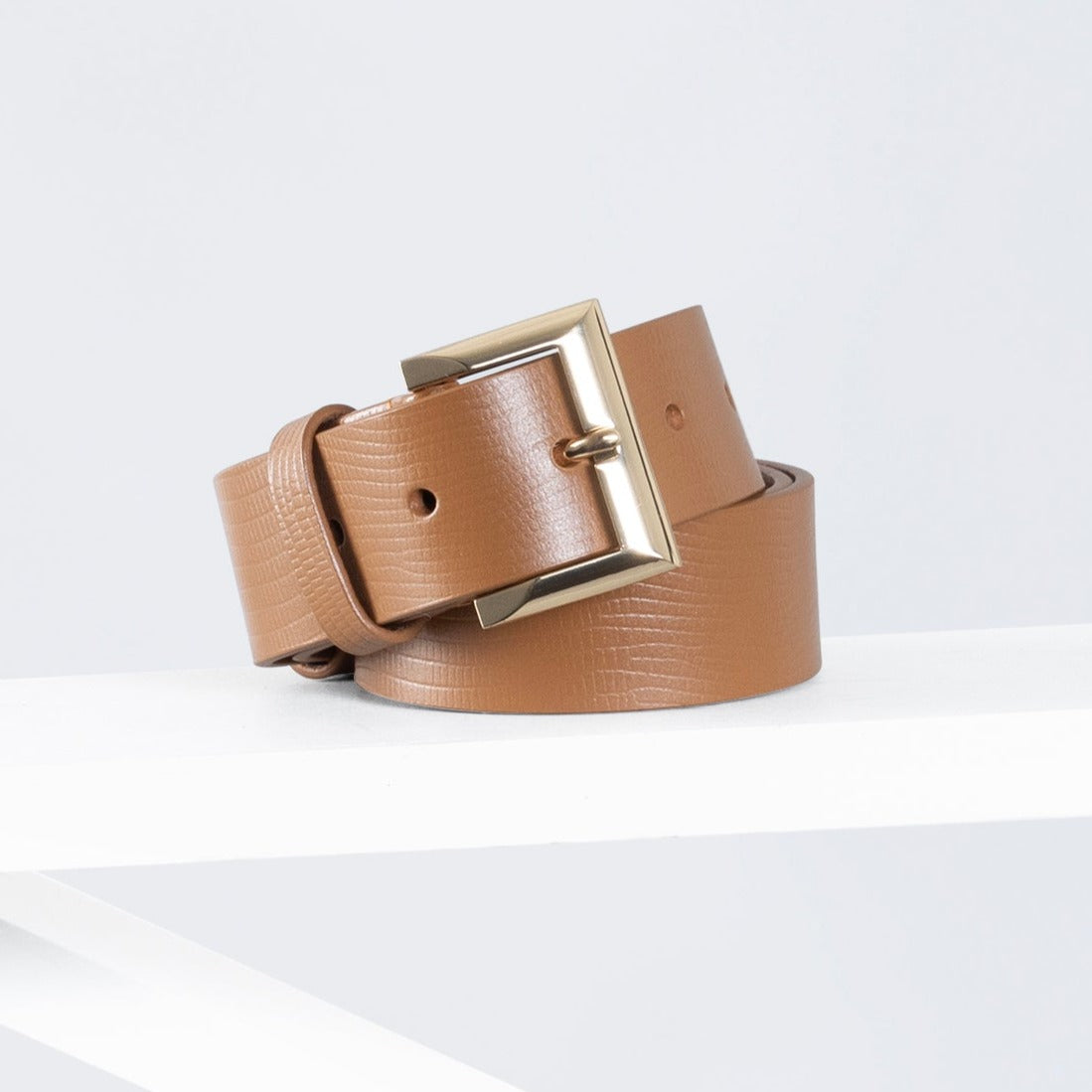 A brown leather belt with a gold buckle, displayed on a white background.
