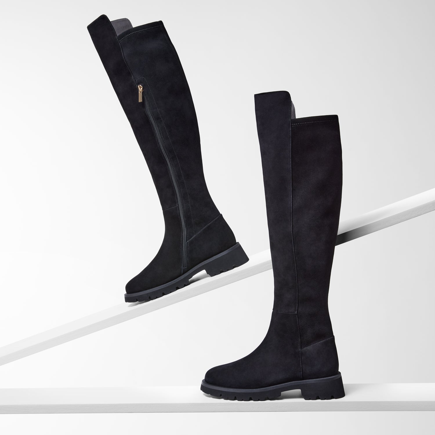 Flat Black knee-high boots on a white background